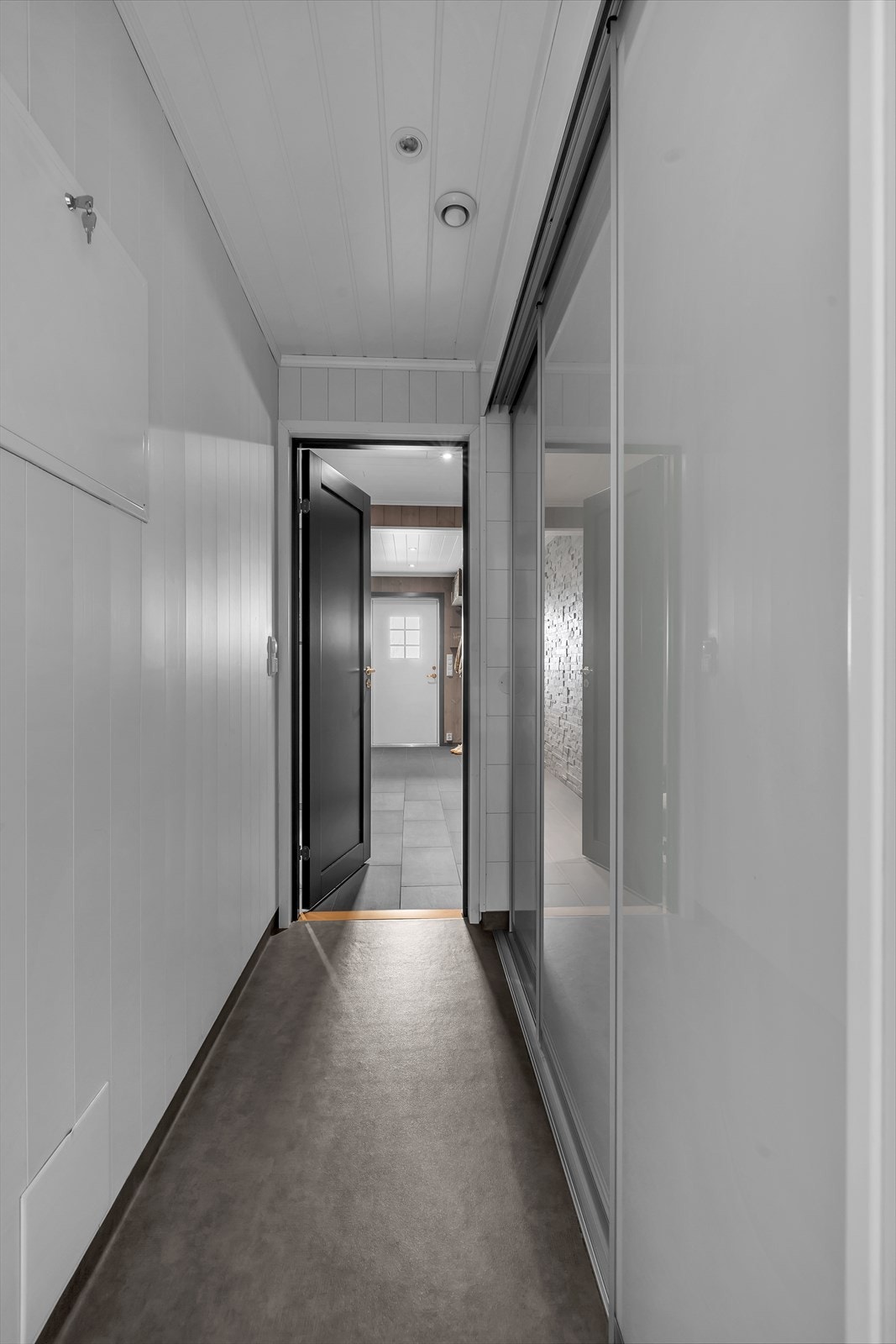 Mellomgang fra entré og inn til vaskerom. Praktisk skyvedørsgarderobe her med mye lagring Galleribilde
