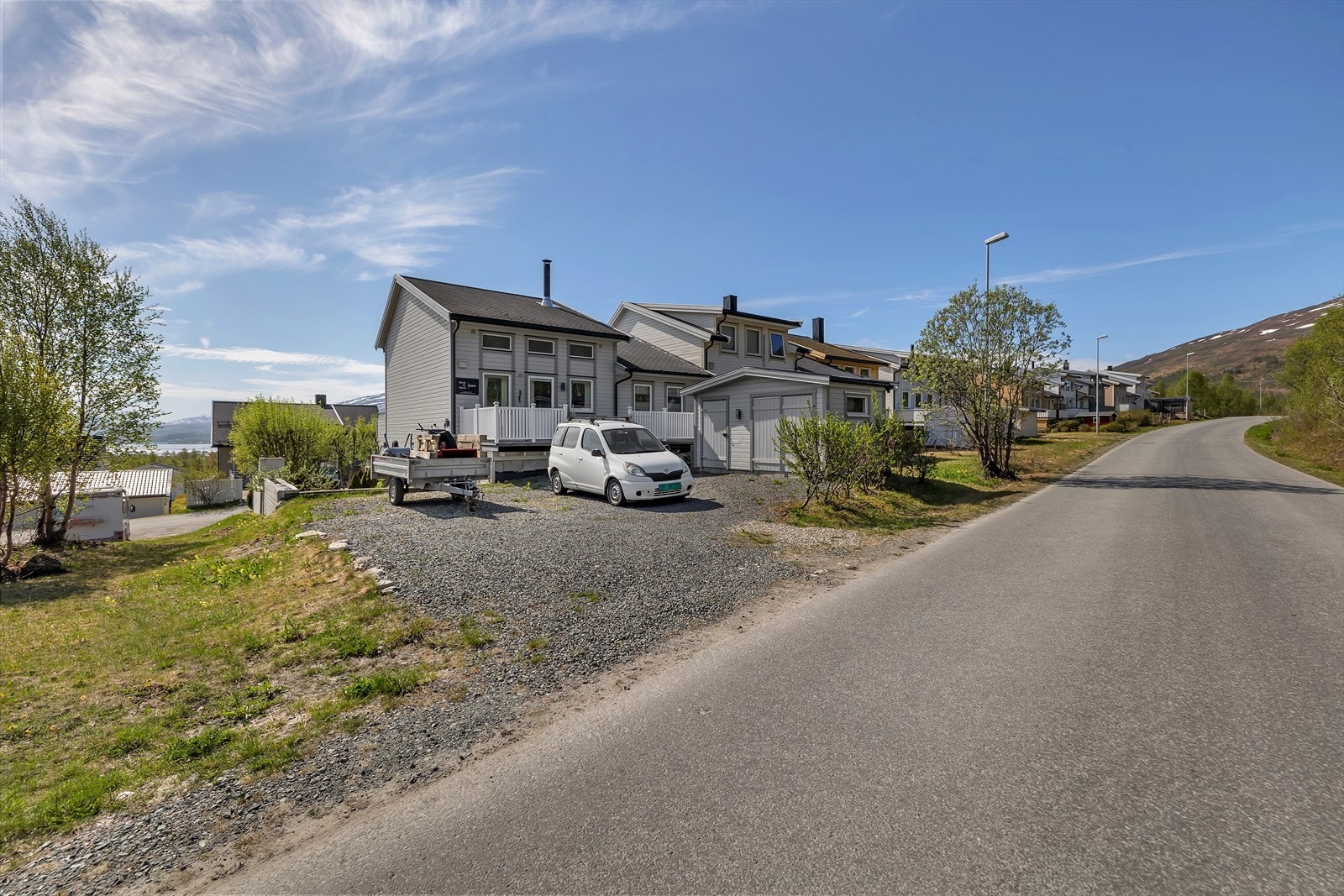 Praktisk frittstående utebod plassert på baksiden av huset. Her er det også etablert ekstra oppstillingsplass til f.eks tilhenger. Nedgang fra terrasse. Denne siden av boligen vender mot friareal på andre siden av vegen. Galleribilde