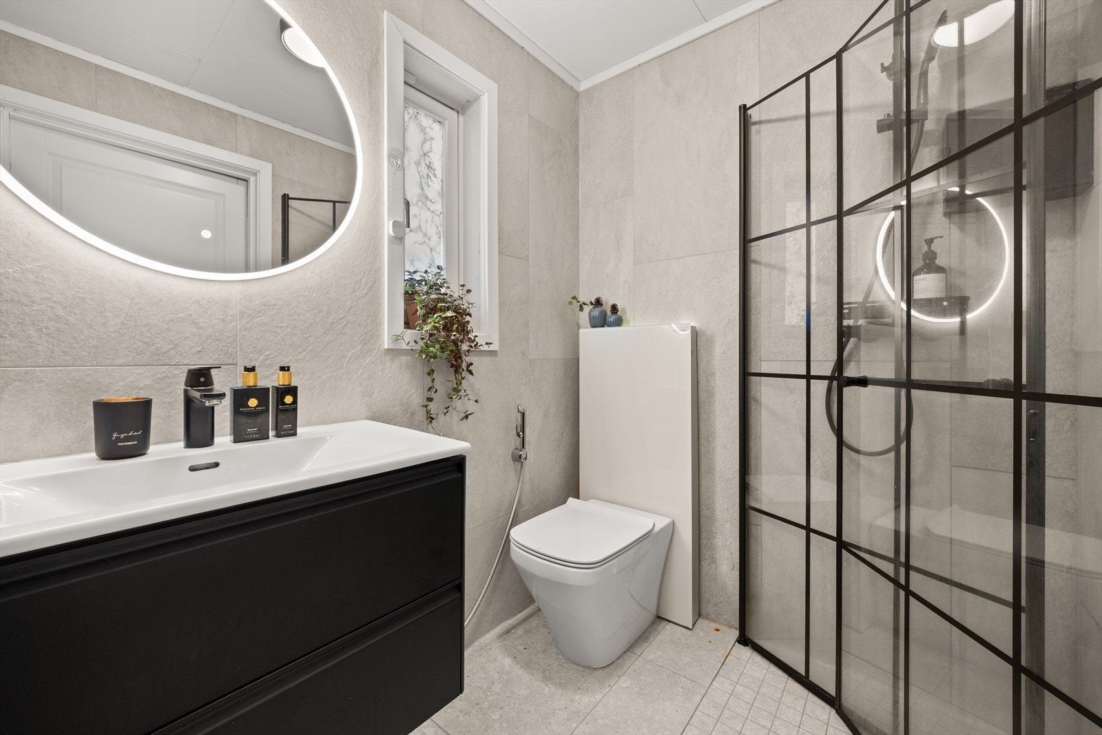 Badet i første etasje er kombinert med vaskerom og har flislagte overflater og gulvvarme. Galleribilde