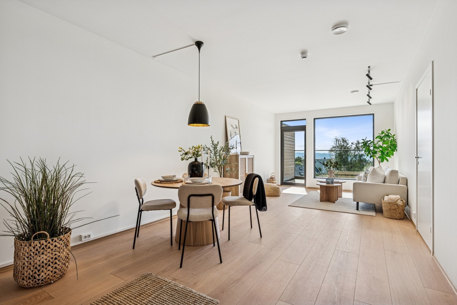 Romslig og moderne oppholdsrom med naturlig plassering av sofa og spisebord. Galleribilde