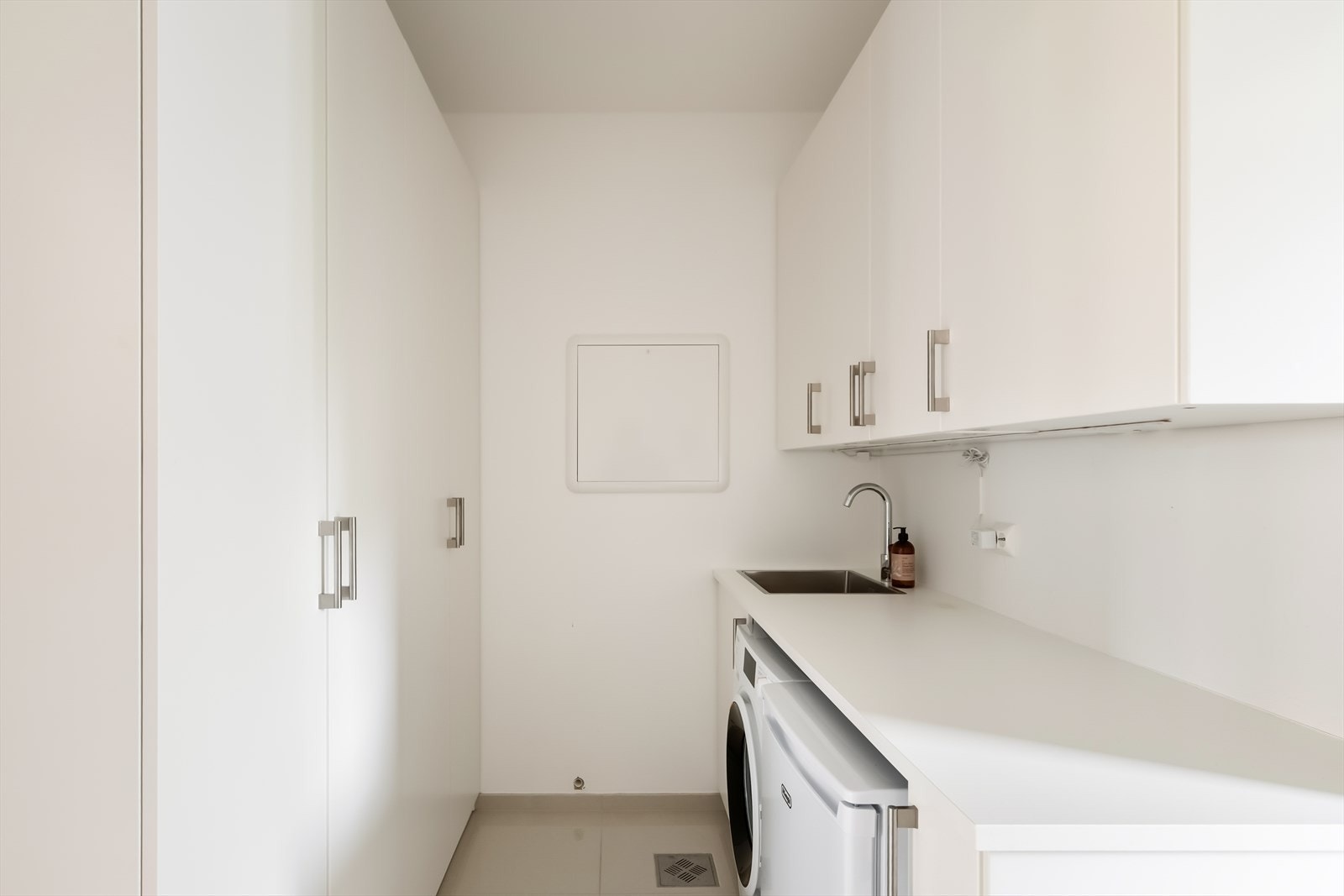 Fra kjøkkenet er det direkte adgang til vaskerommet, som er innredet med benkeplate, utslagsvask, over- og underskap, samt opplegg og god plass til vaskemaskin og tørketrommel. Galleribilde