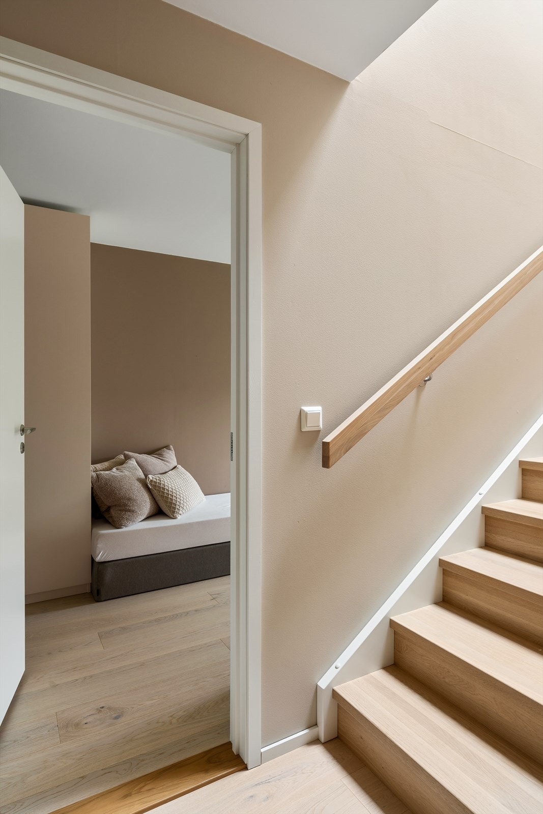 Den enstavs, hvitbeisede eikeparketten fortsetter ned i underetasjen og binder rommene elegant sammen. Galleribilde