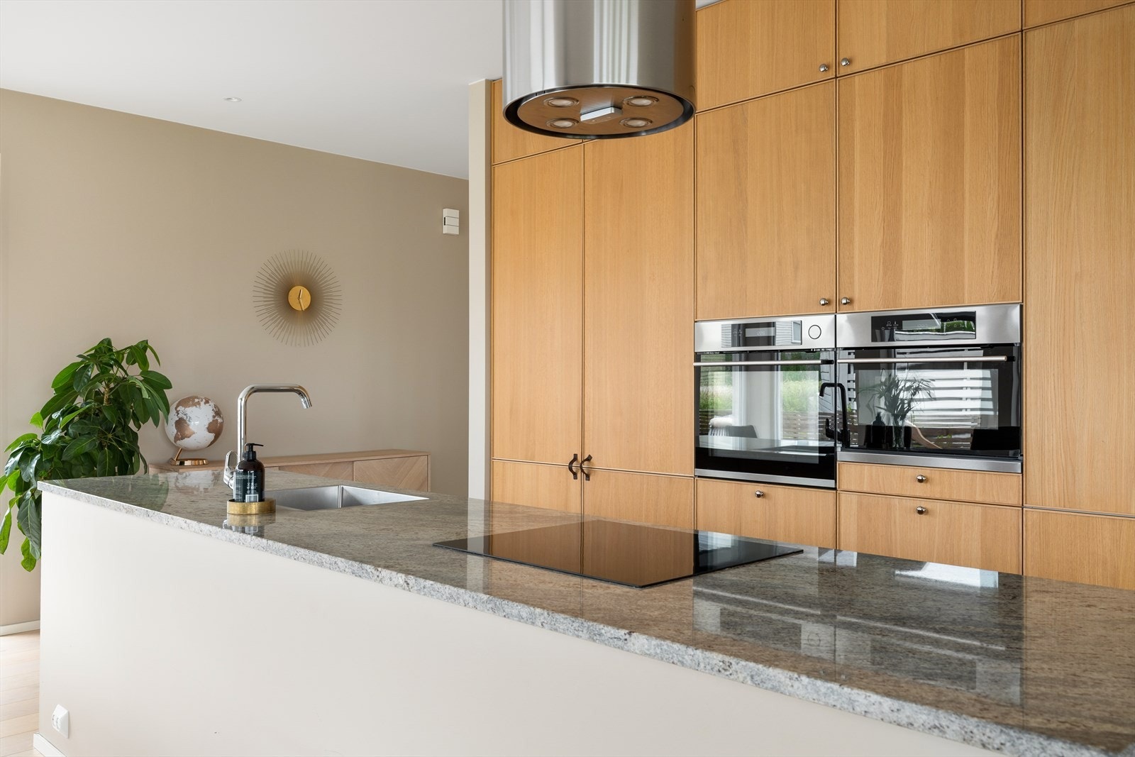 Kjøkkenbenken er i elegant granitt med nedfelt vask og platetopp vendt mot stue - ideelt for sosial matlaging. Galleribilde