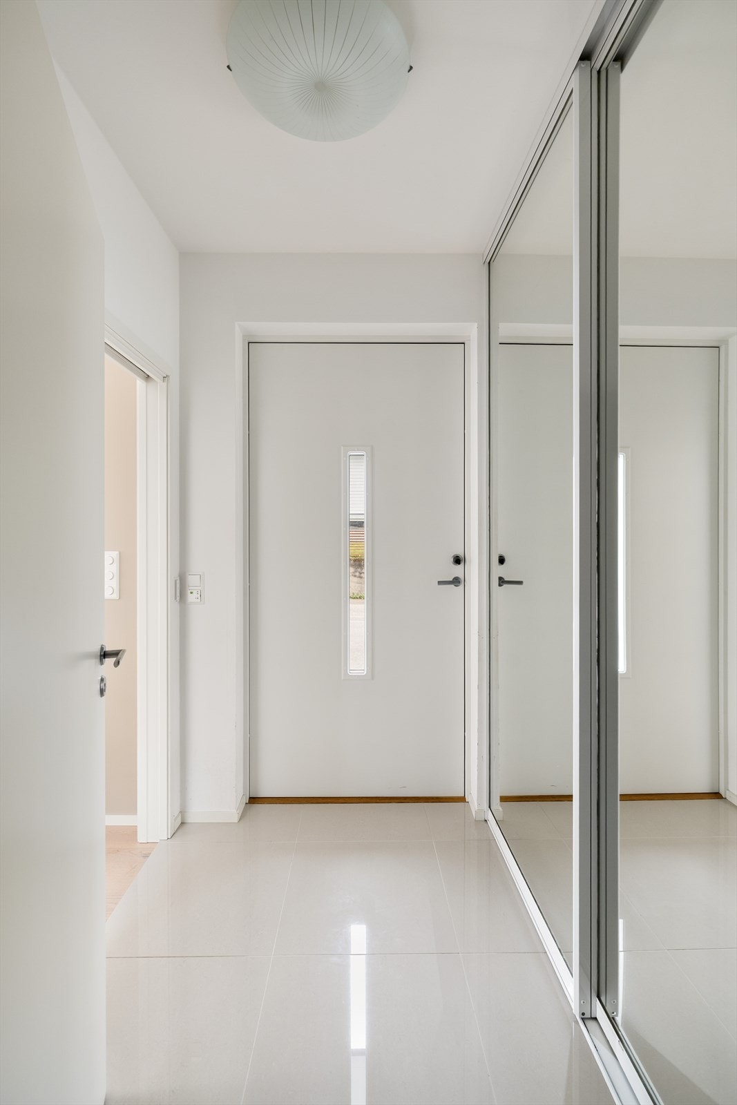Gang med god oppbevaringsplass i en praktisk skyvedørsgarderobe med speilfronter som skaper romfølelse. Galleribilde