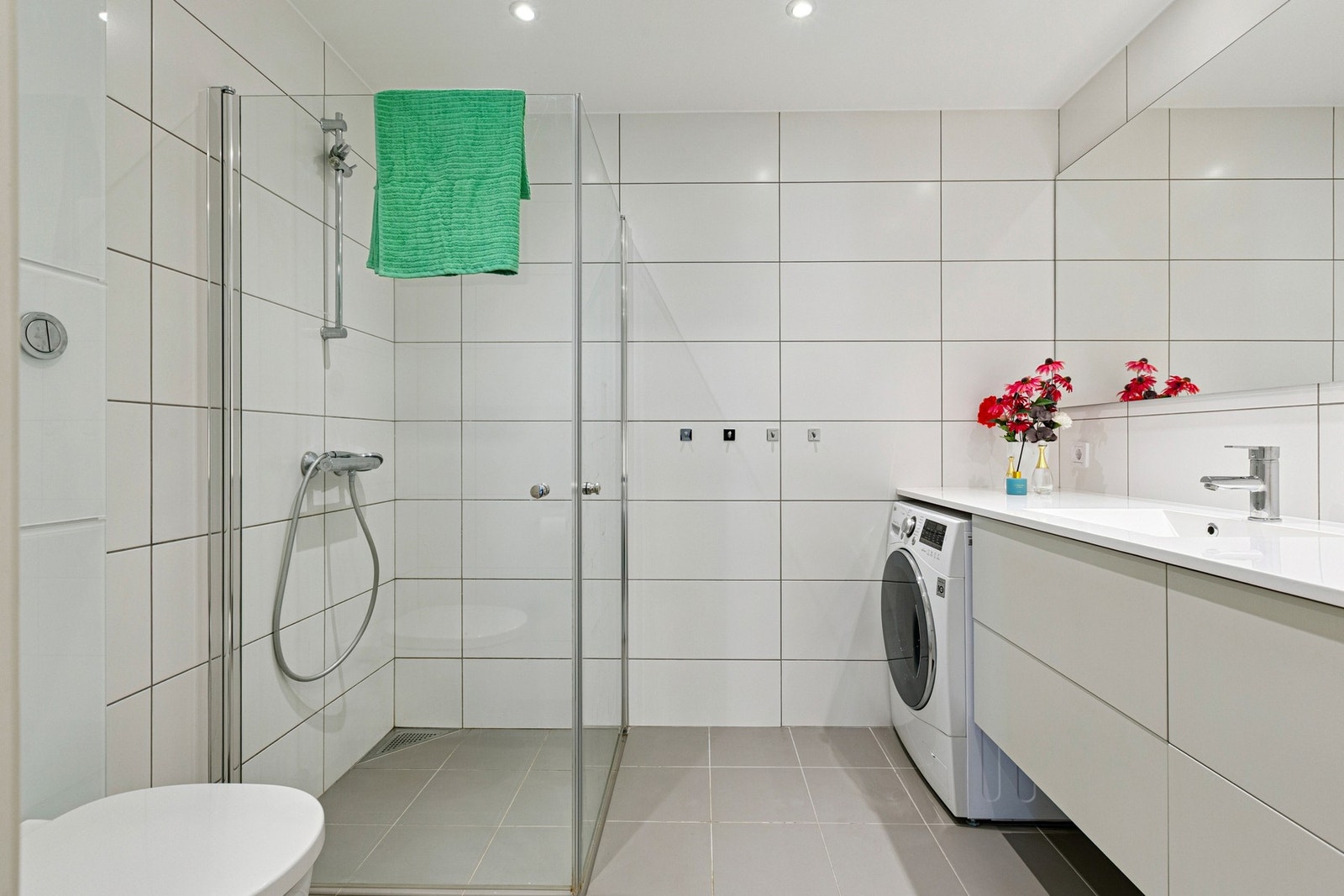 Delikat og funksjonelt bad på 5 kvm, med flislagte overflater og rikelig oppbevaring i servantinnredningen. Galleribilde