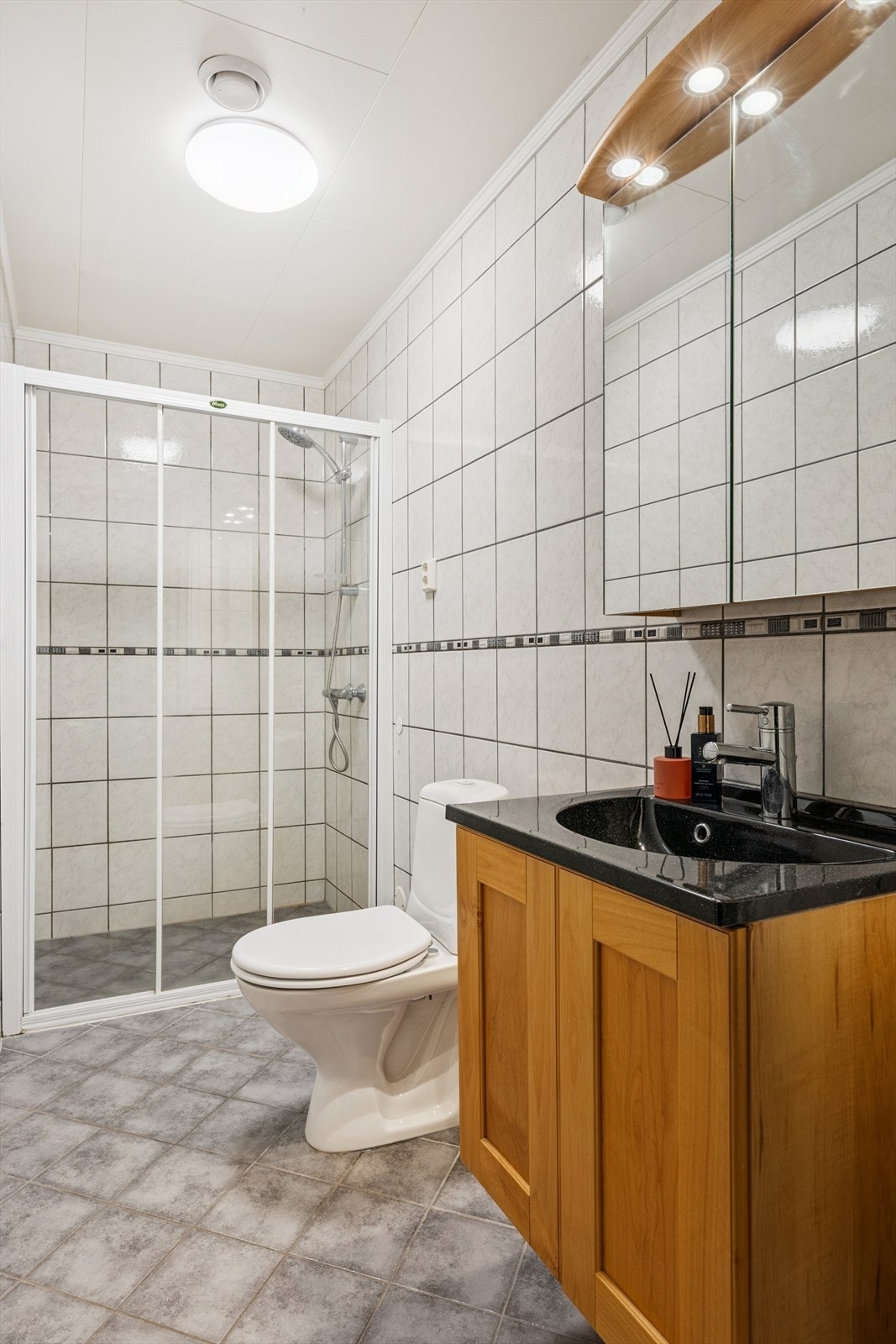 Badet i underetasjen har lyse fliser med grå nyanser som gir et friskt preg. Galleribilde