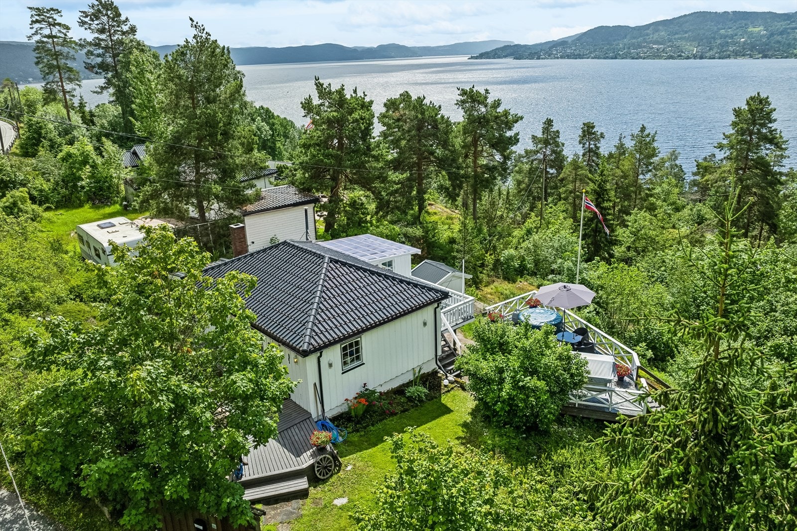 Eiendommen er på ca. 1 130 kvm eiet med flotte solrike uteplasser/terrasser. Gruset innkjørsel med separat garasje. Galleribilde