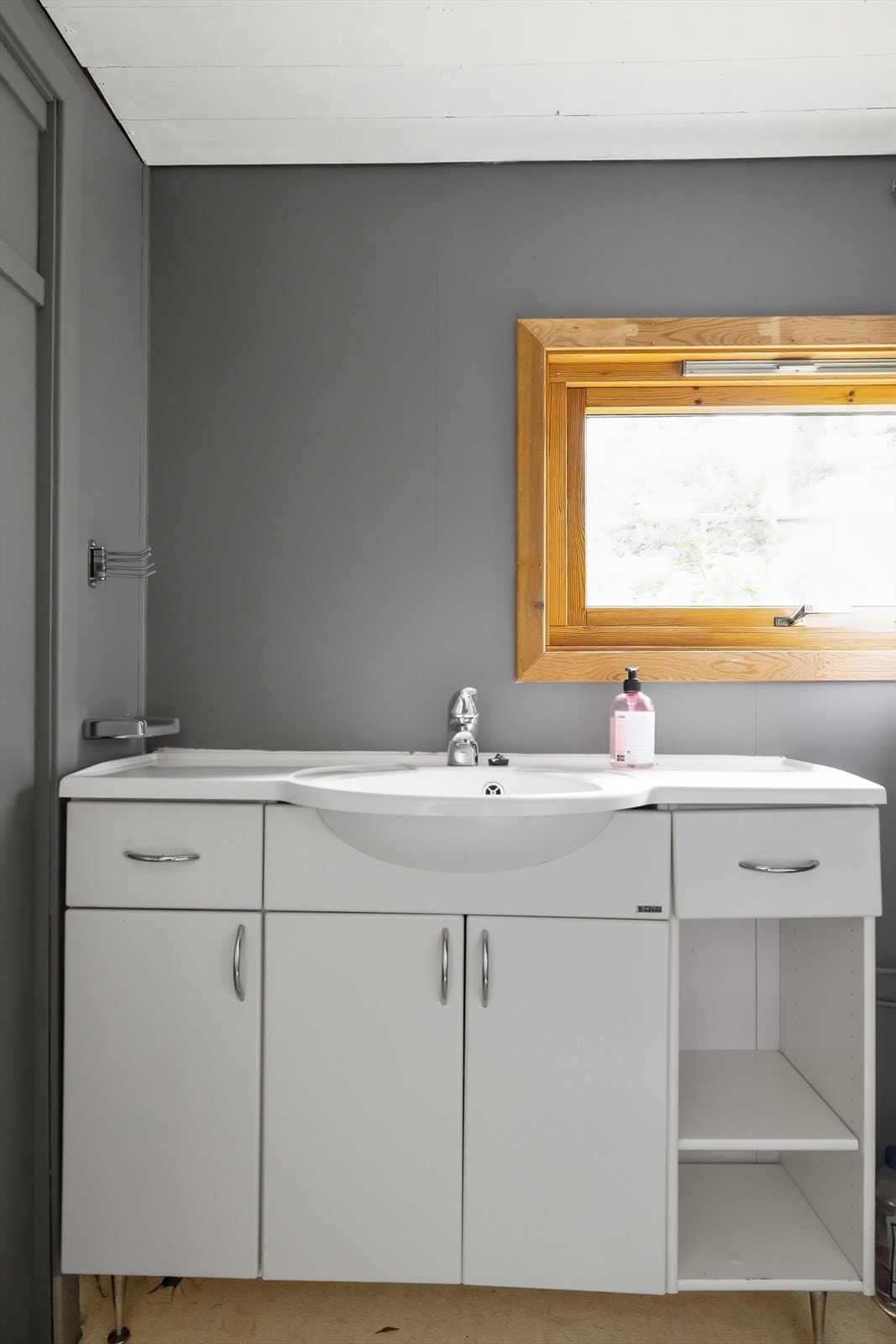 Hytta har et baderom med vinylbelegg på gulv, baderomsinnredning bestående av benkeskap med profilerte fronter og dusjkabinett. Galleribilde