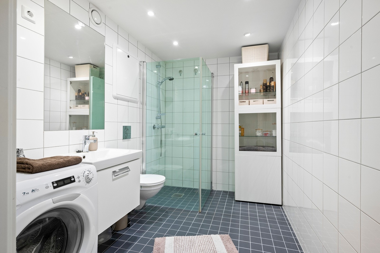 Innbydende og meget romslig bad med flislagte vegg- og gulvflater og varme i gulv samt downlights i himling Galleribilde