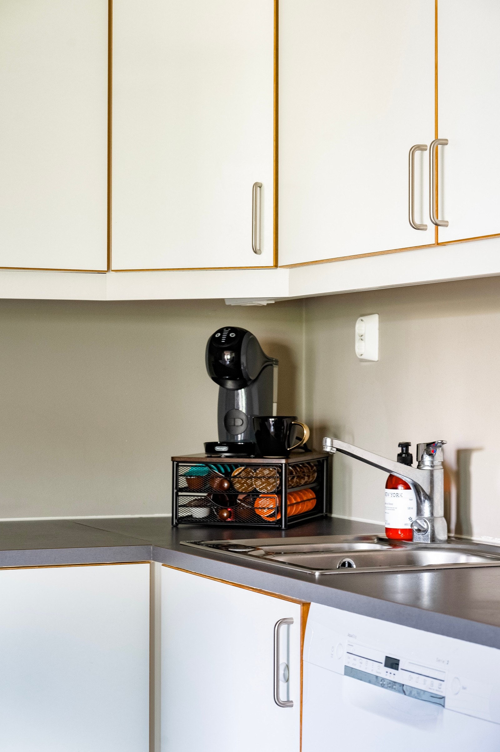 Innredning med hvite glatte skapfronter, laminat benkeplater, nedfelt rustfri oppvaskkum og ett-greps armatur Galleribilde