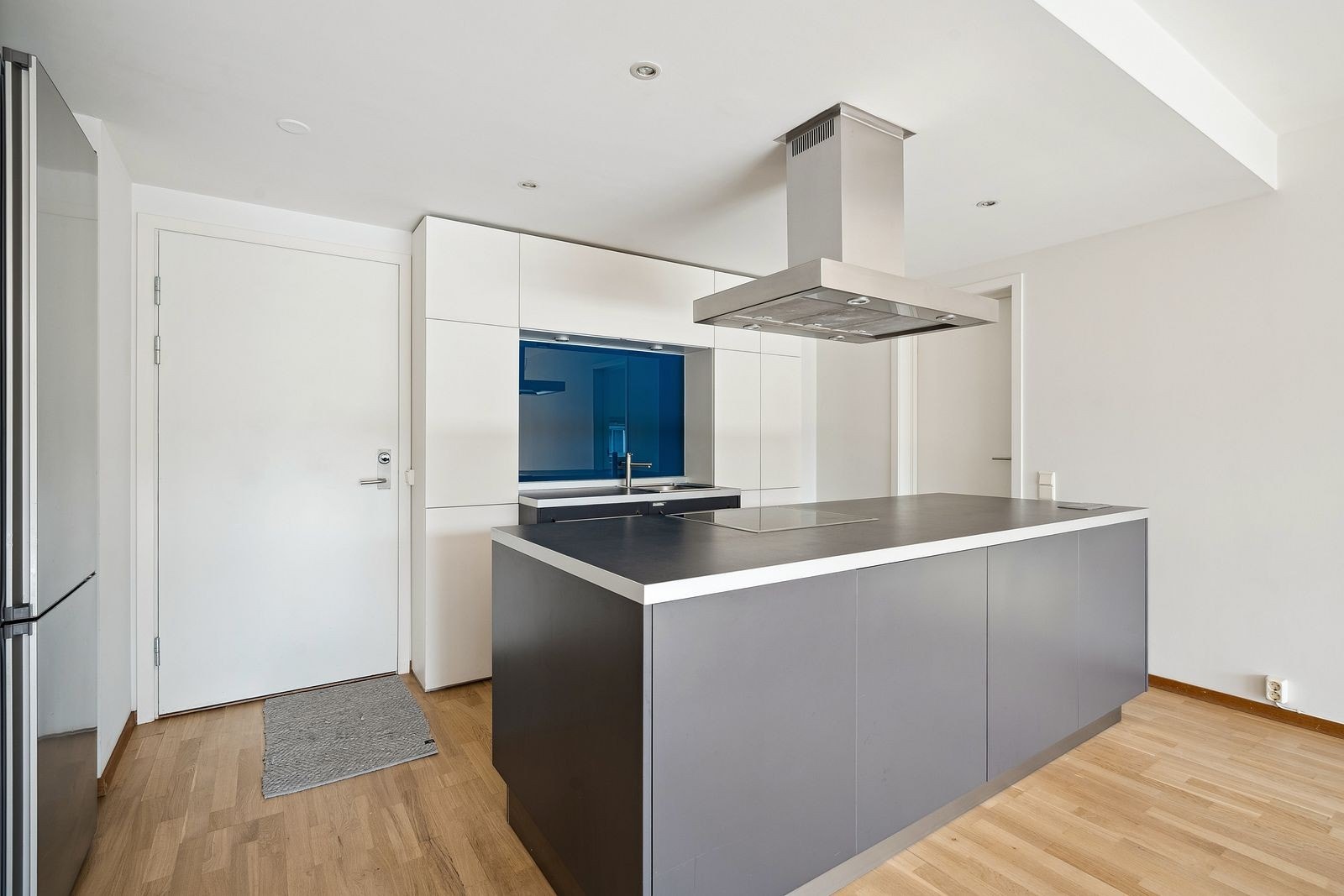 Flott kjøkken med integrert stekeplate og stekeovn i kjøkkenøy, integrert oppvaskmaskin. Galleribilde