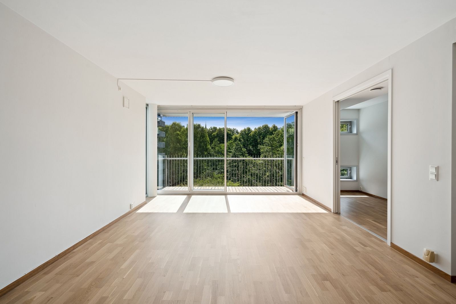 Fullt åpningsbar skyvedør gir direkte tilgang til balkongen og lar naturen bli en del av stuen. Galleribilde