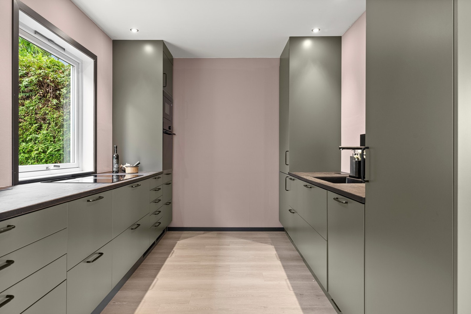 Det er rikelig med oppbevaringsplass langs med to vegger, og den generøse benkeplassen gjør matlagingen både enkel og effektiv. Galleribilde