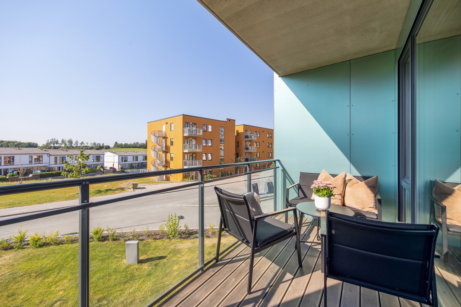 Terrassen har dekke i tre, og rekkverket i stål har store glassplater. Galleribilde