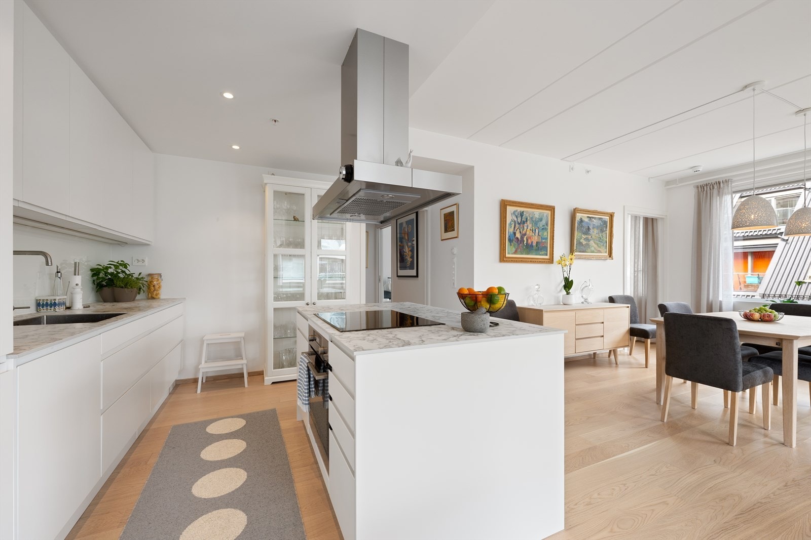 Kjøkkenet har en moderne innredning med glatte fronter og en praktisk, frittstående kjøkkenøy som skaper både arbeidsplass og sosial sone Galleribilde