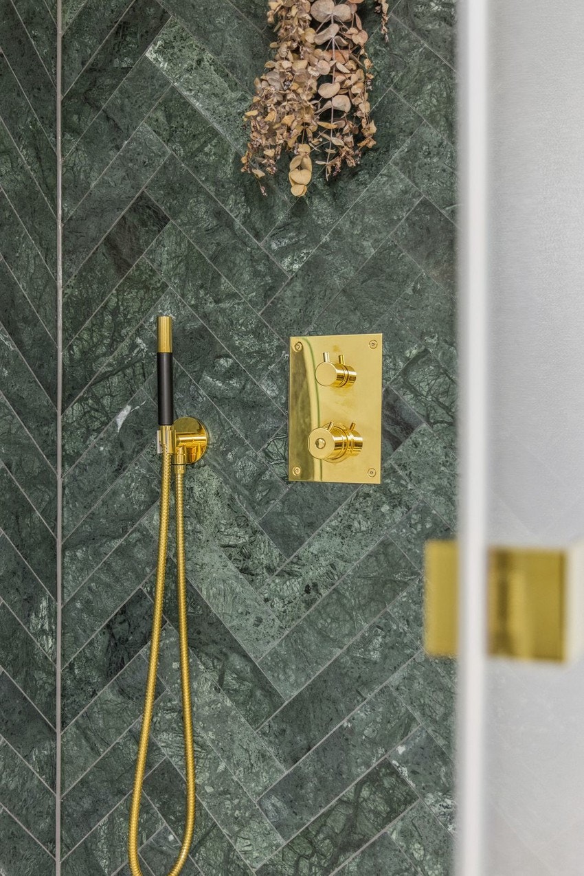 Gulvet er belagt med store marmor-mønstrede fliser og i dusjsonen er det lekre mørkegrønne fliser i fiskebeinsmønster Galleribilde