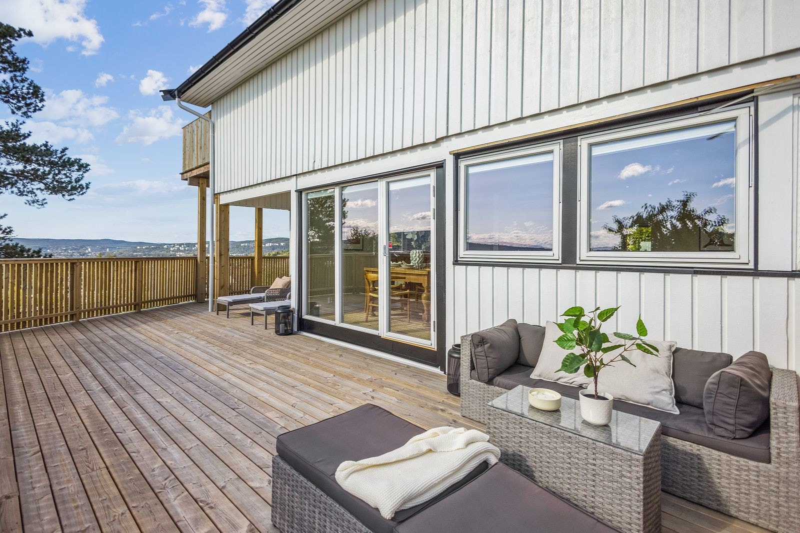 Utgang fra stue/ kjøkken til skjermet og delvis overbygd veranda på hele 45 m² Galleribilde