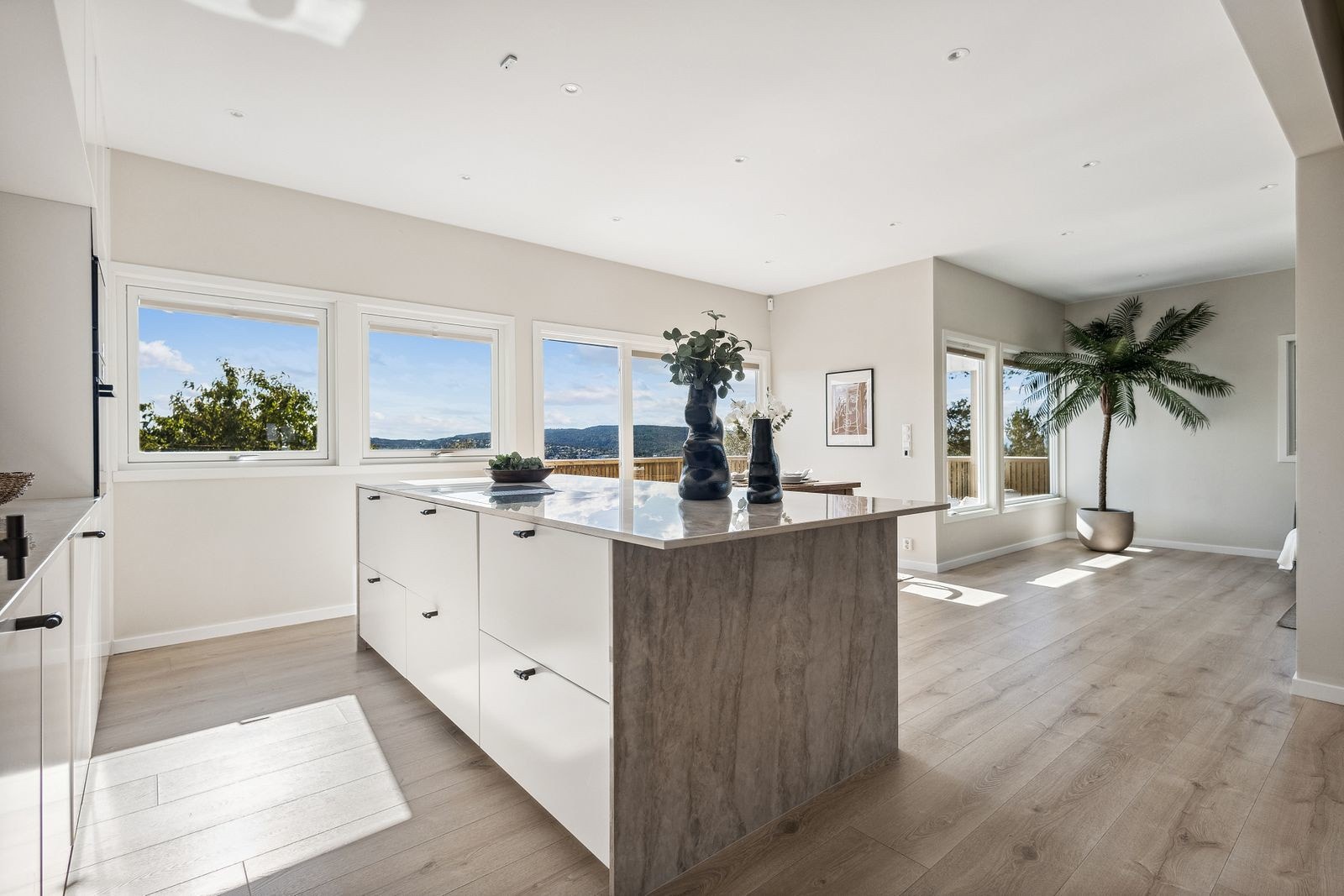 Lekkert kjøkken i åpen løsning mot stue. Kjøkkenøya byr på ekstra oppbevarings- og arbeidsplass Galleribilde