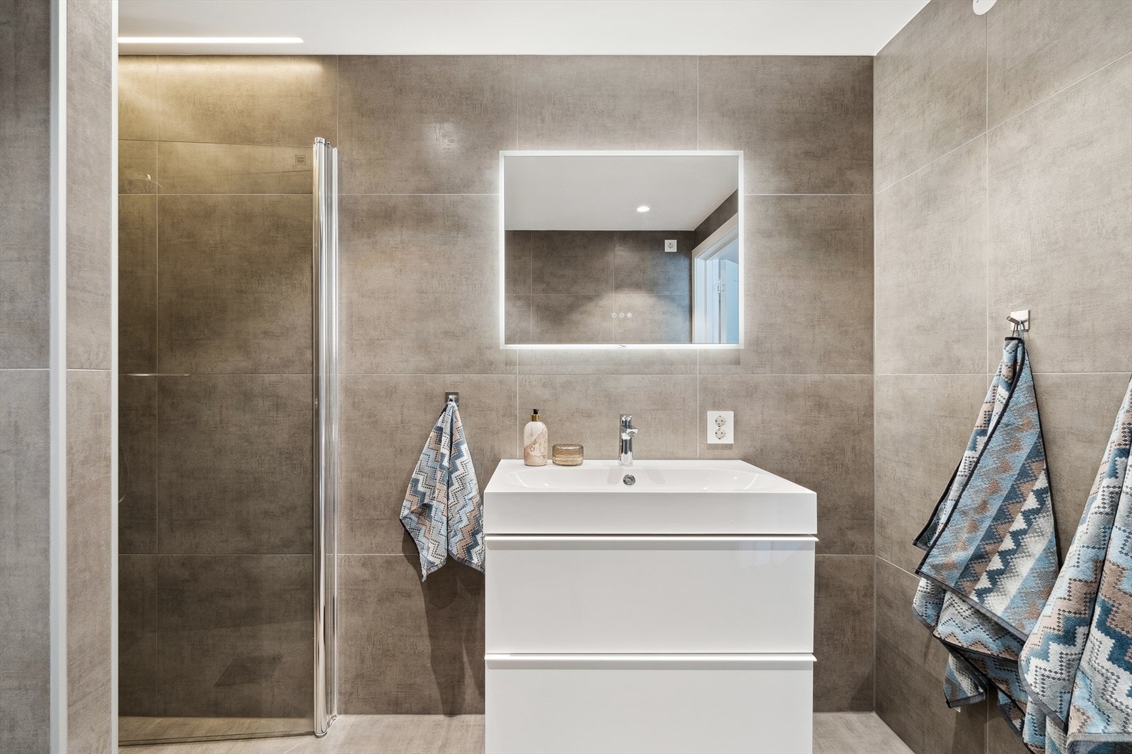 Badet er innredet med tidsriktig servantinnredning, skap, dusjnisje, vegghengt wc - opplegg for vaskemaskin/tørketrommel Galleribilde