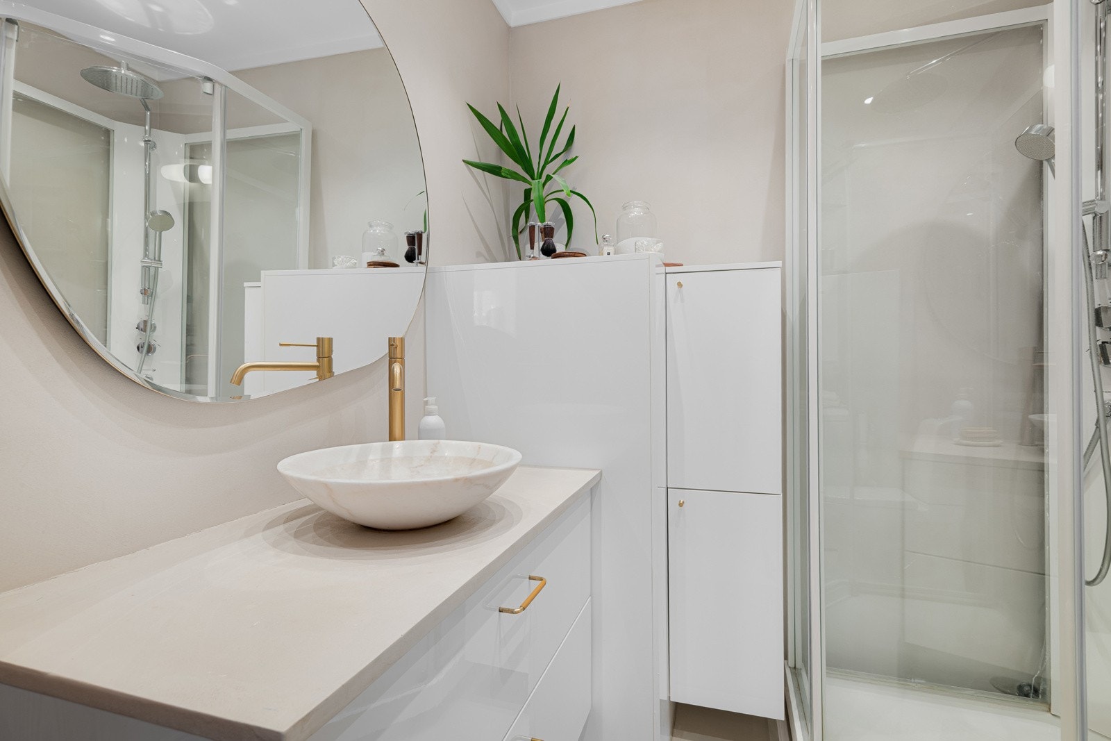 Rommet er innredet med servantskap, marmorvask/servant, speil, vegghengt belysning, dusjkabinett, gulvstående toalett og opplegg for vaskemaskin (vaskemaskin følger med). Galleribilde