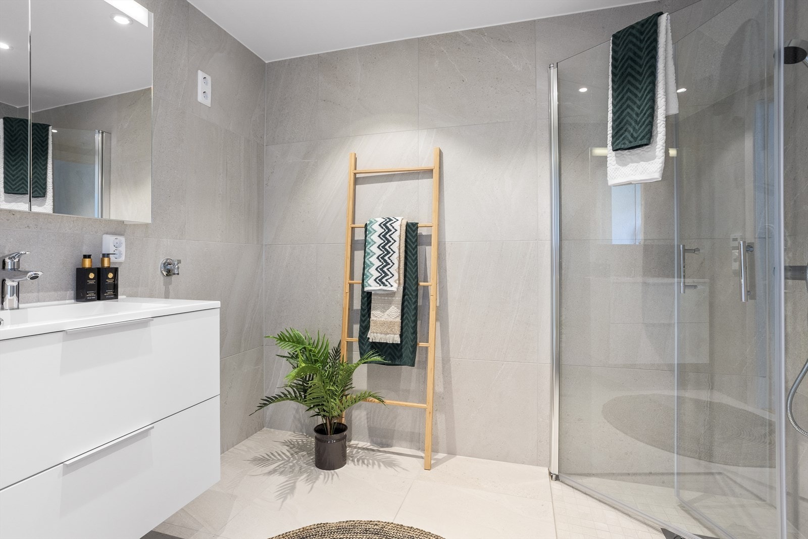 Delikat og romslig bad utstyrt med flott baderomsinnredning, ferdig opplegg for vaskemaskin og varme i gulv. Her er det gjort tilvalg med 60x60 fliser på gulv og vegger, samt speilskap over vask. Galleribilde