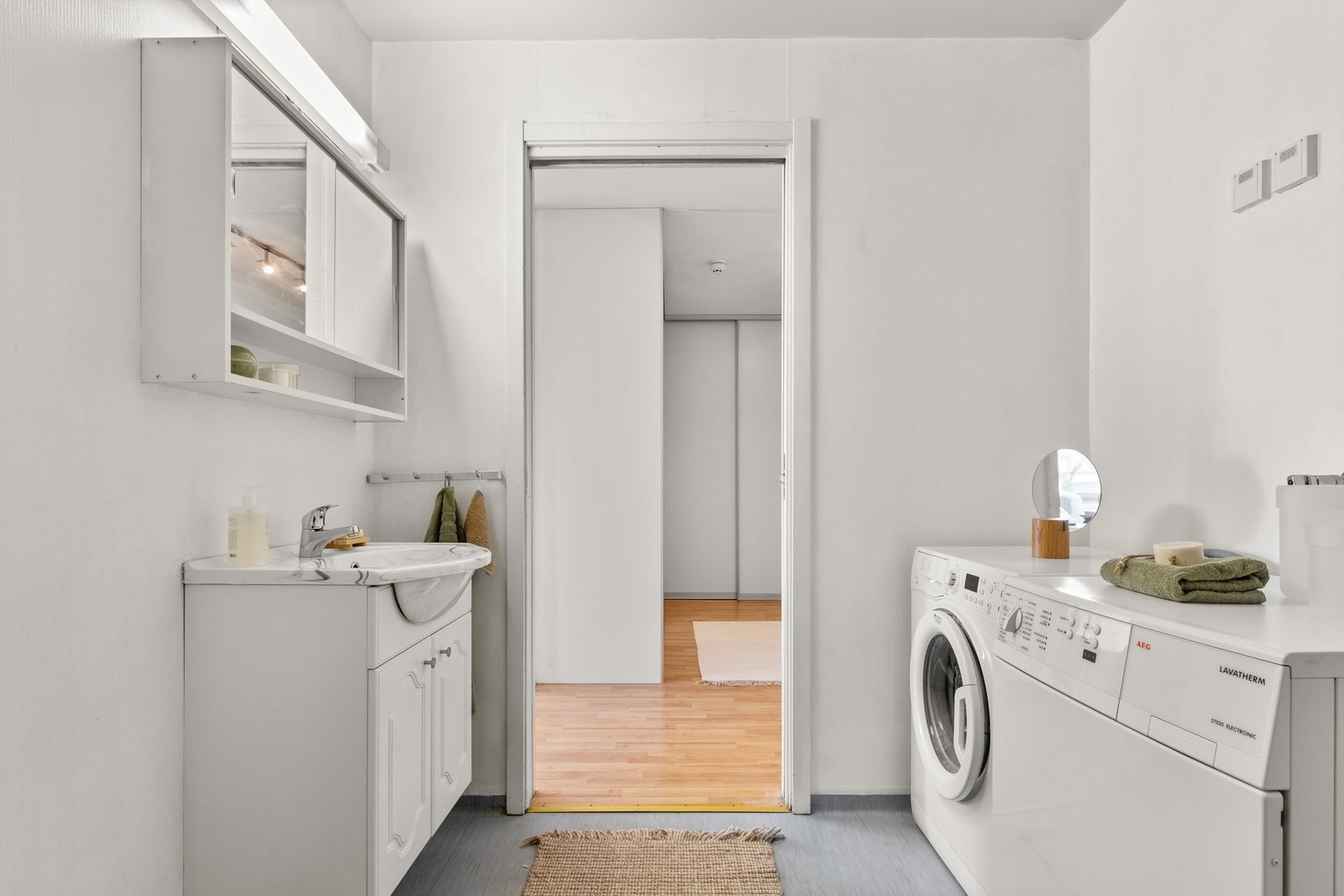 Badet har vegger med tapet og gulv med vinylbelegg. Baderomsinnredningen består av servantskap med servant. Over servanten er det et speilskap. Galleribilde