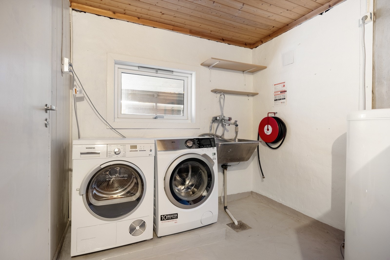 Vaskerommet er todelt og innredet med vaskemaskin, tørketrommel, utslagsvask og varmtvannsbereder. Galleribilde