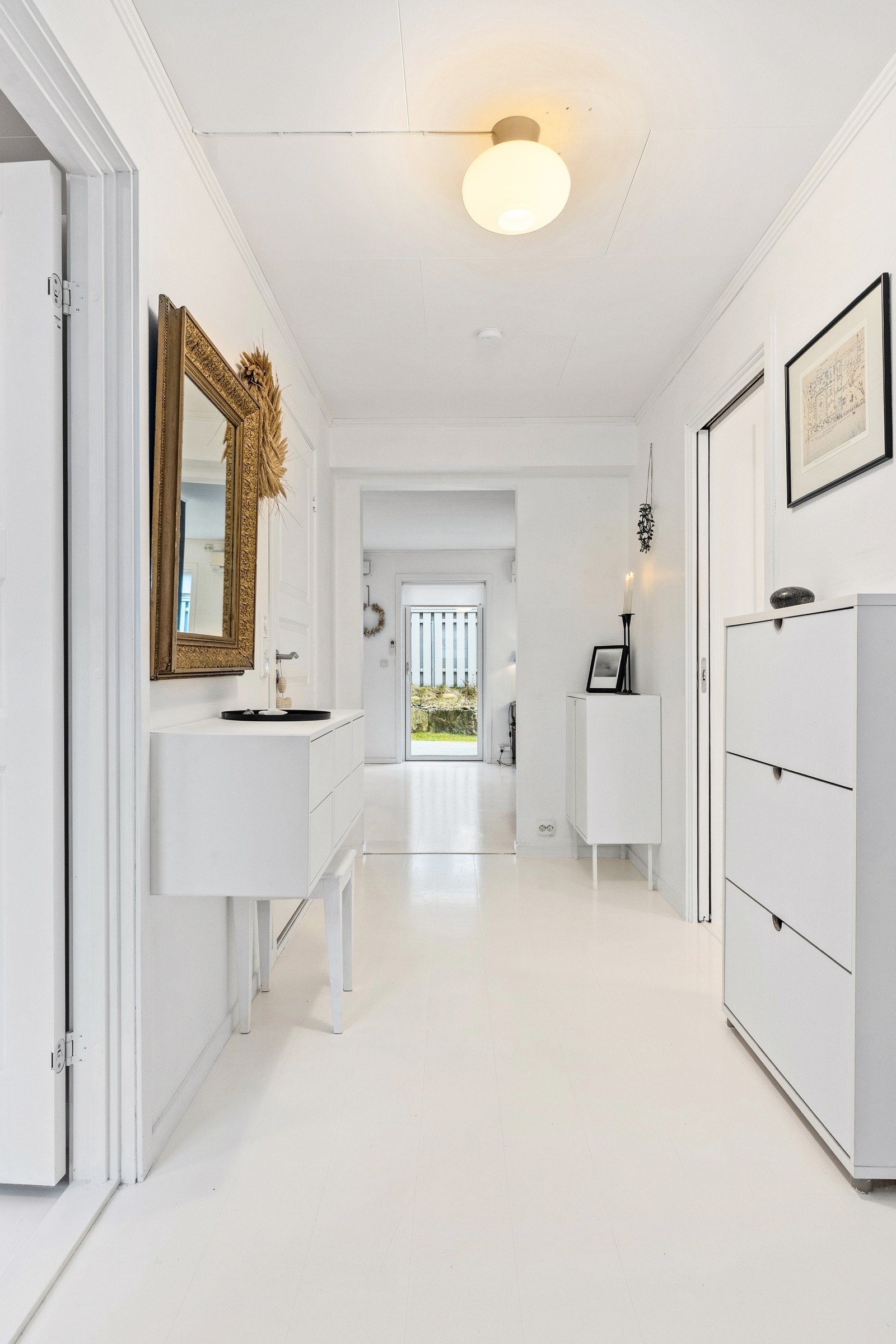 Lys og innbydende gang med plass til garderobeskap, kommode eller lignende. Galleribilde