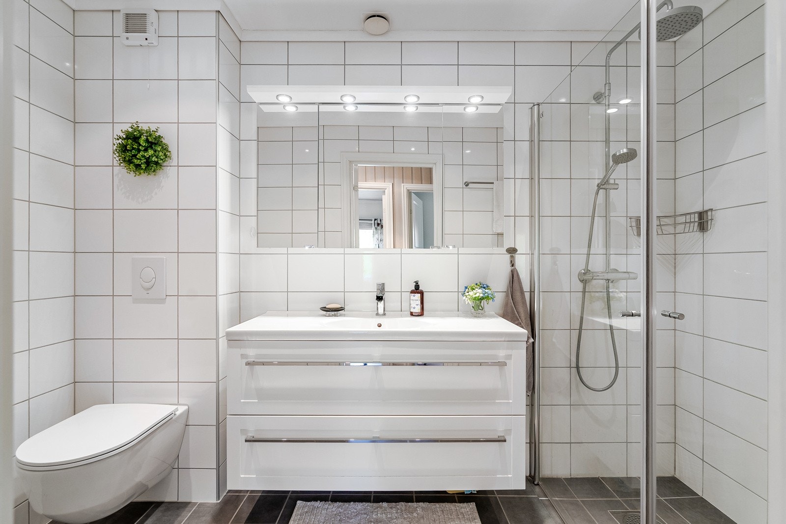 Badet i hovedetasjen er flislagt på gulv og vegger Galleribilde