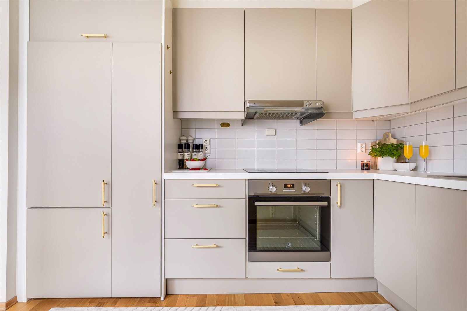 Kjøkkenet er utstyrt med integrerte hvitevarer som komfyr, stekeplate, kjøleskap med frys og oppvaskmaskin Galleribilde