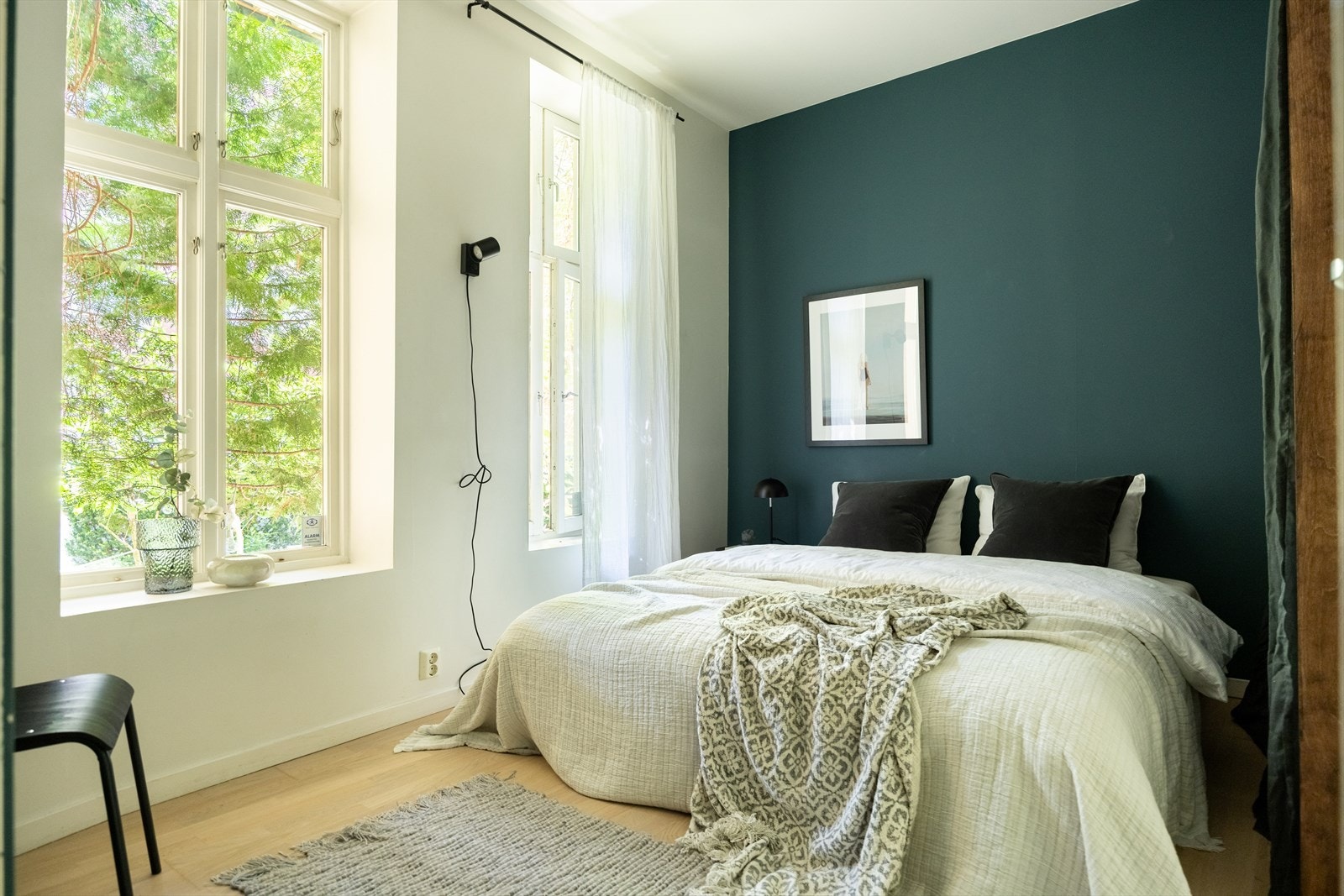 Lyst og romslig soverom med plass til dobbeltseng og nattbord Galleribilde