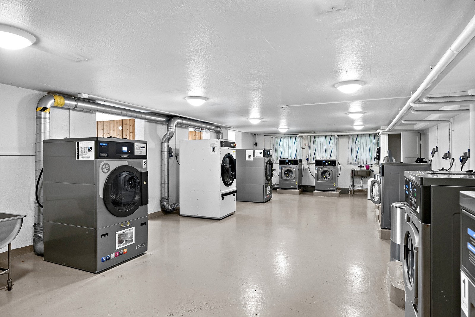 Praktisk fellesvaskeri med store industrimaskiner. Galleribilde