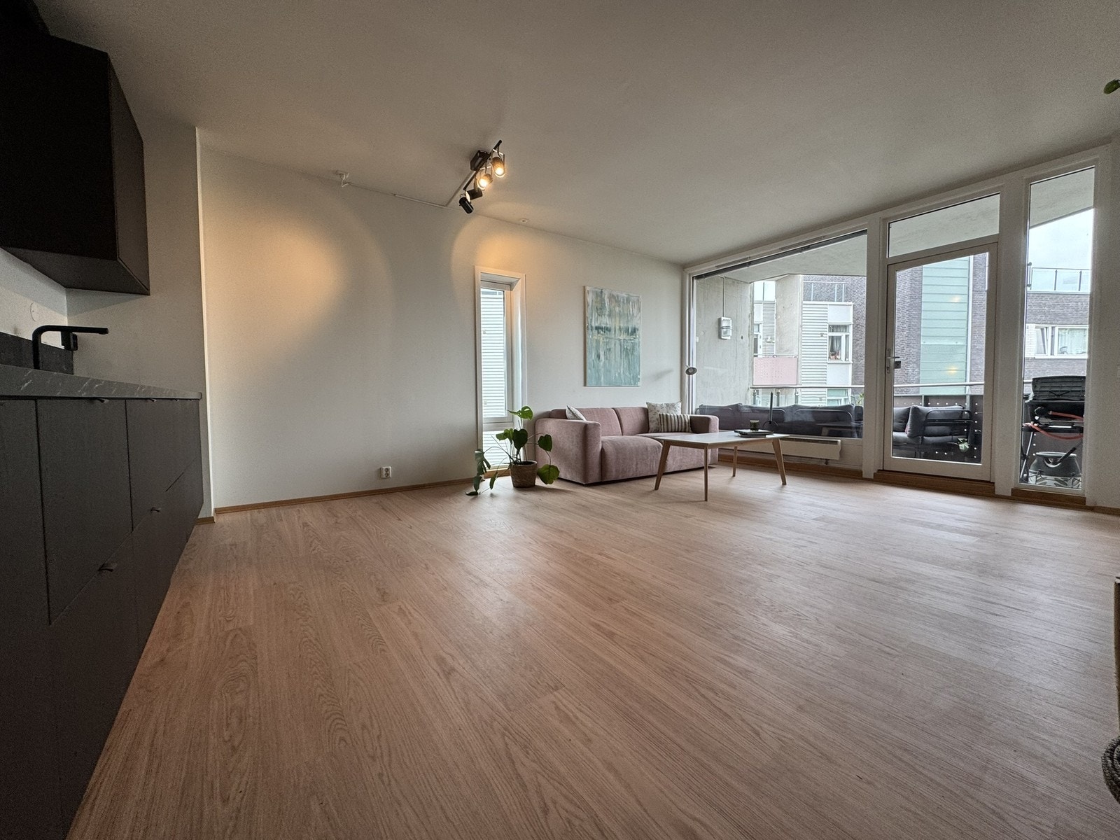 Stue med utgang til balkong. Stuebord og sofa, samt stålampe følger. Galleribilde