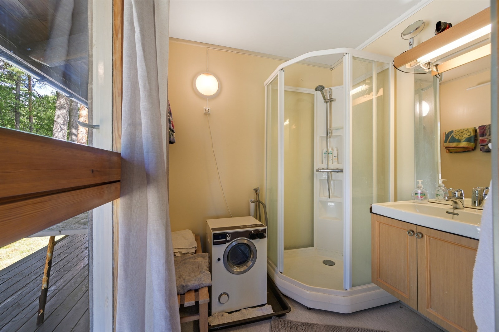 Badet er innredet med servant i baderomsinnredningen, dusjkabinett og opplegg for vaskemaskin Galleribilde