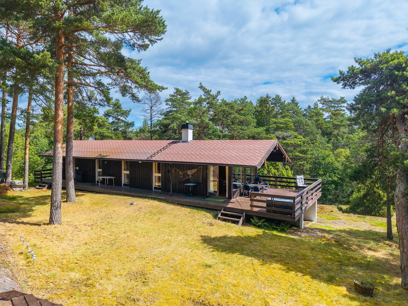 Stor, solfylt terrasse og flere koselig uteplasser på den flotte naturtomten. Galleribilde