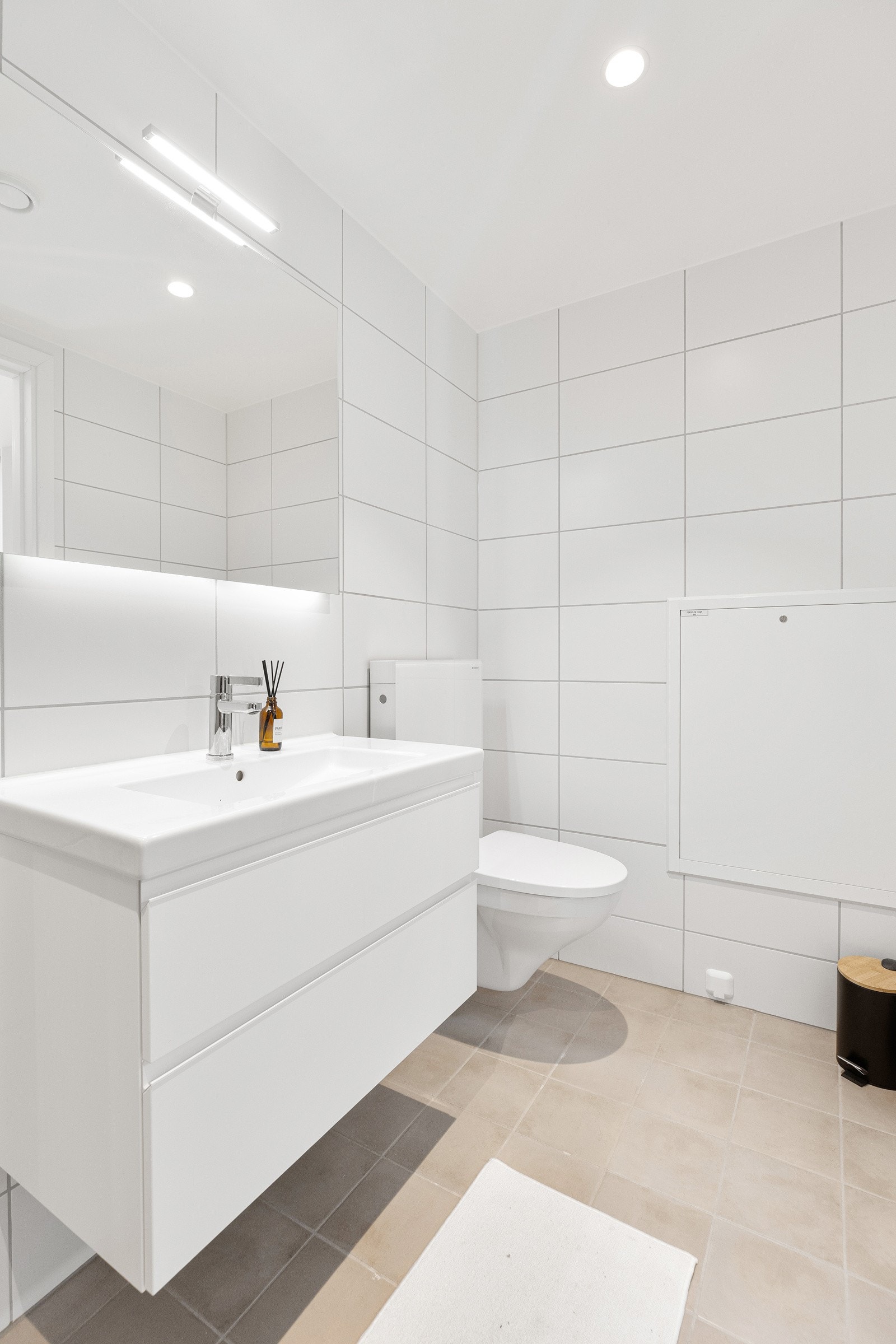 Innredning med glatte fronter og speil med lys i rommet - gulvvarme og downlights Galleribilde