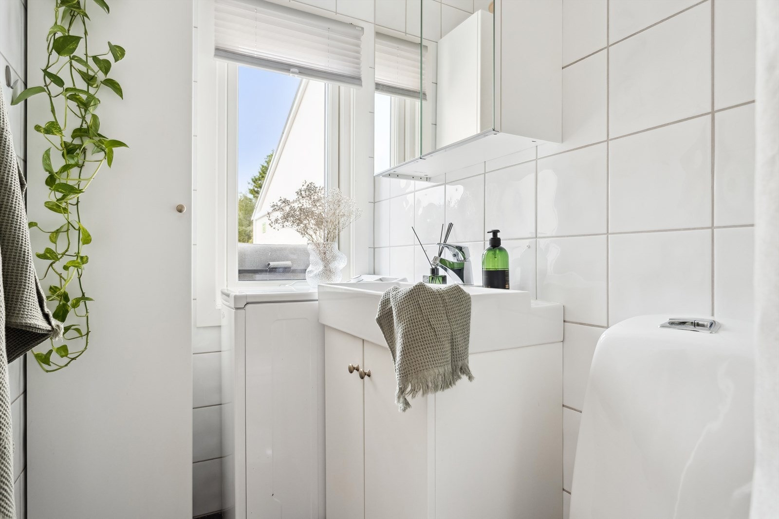 Badet er innredet med toalett, dusjhjørne, servant med under- og overskap samt et høyskap. Det er vaskemaskin på badet, denne medfølger handelen. Galleribilde