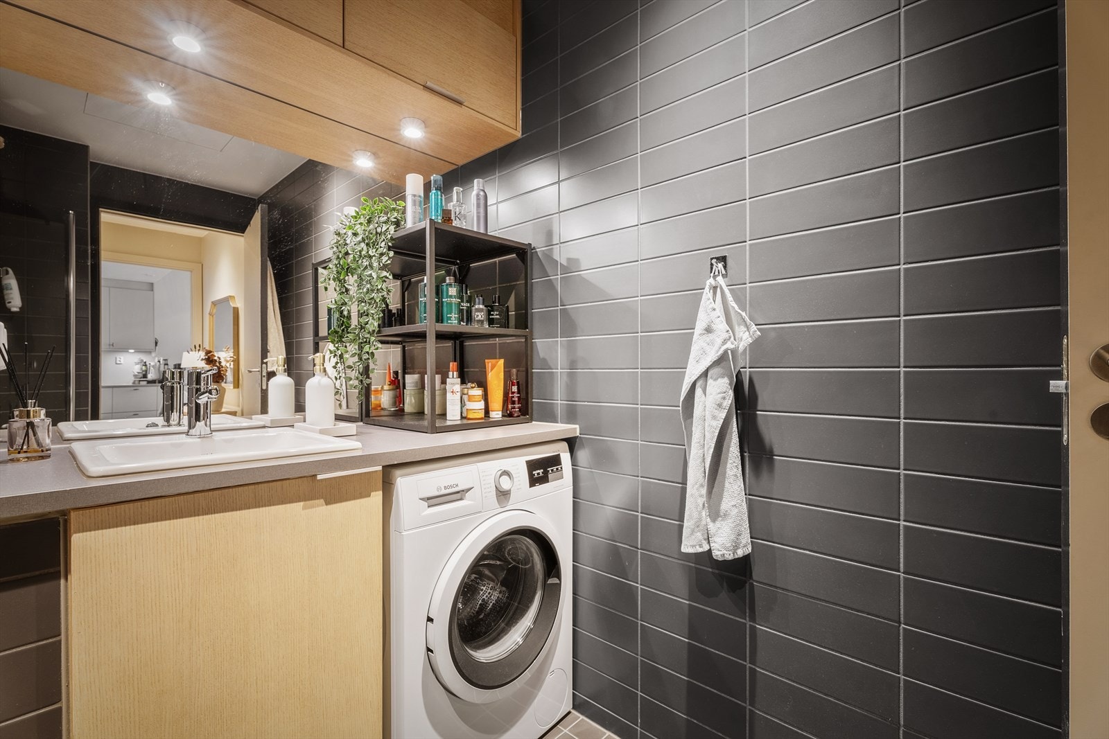 Servant med underskap, speil med belysning og opplegg for vaskemaskin. Galleribilde