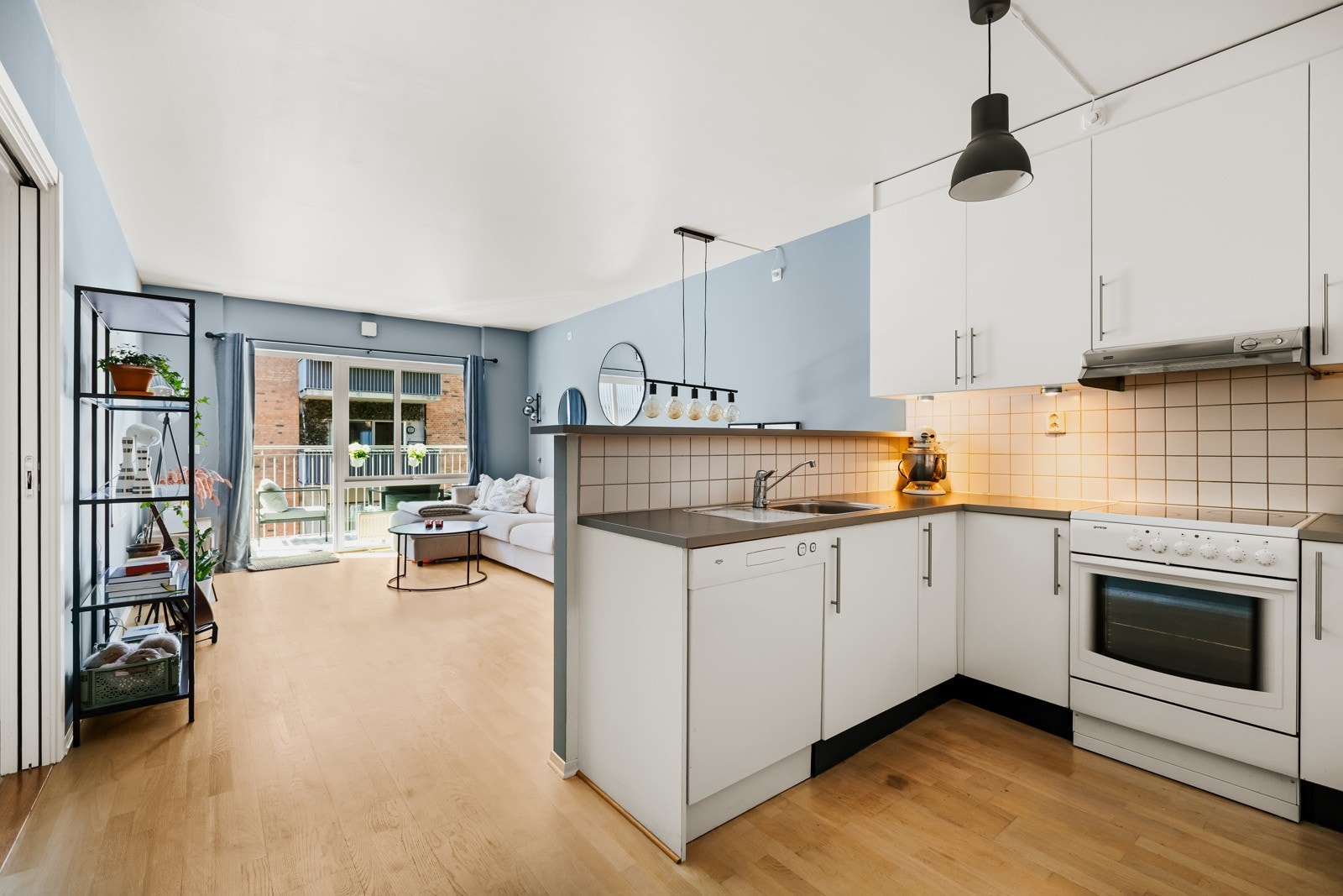 Praktisk åpen stue- og kjøkkenløsning med smart halvvegg som skaper en naturlig soneinndeling Galleribilde