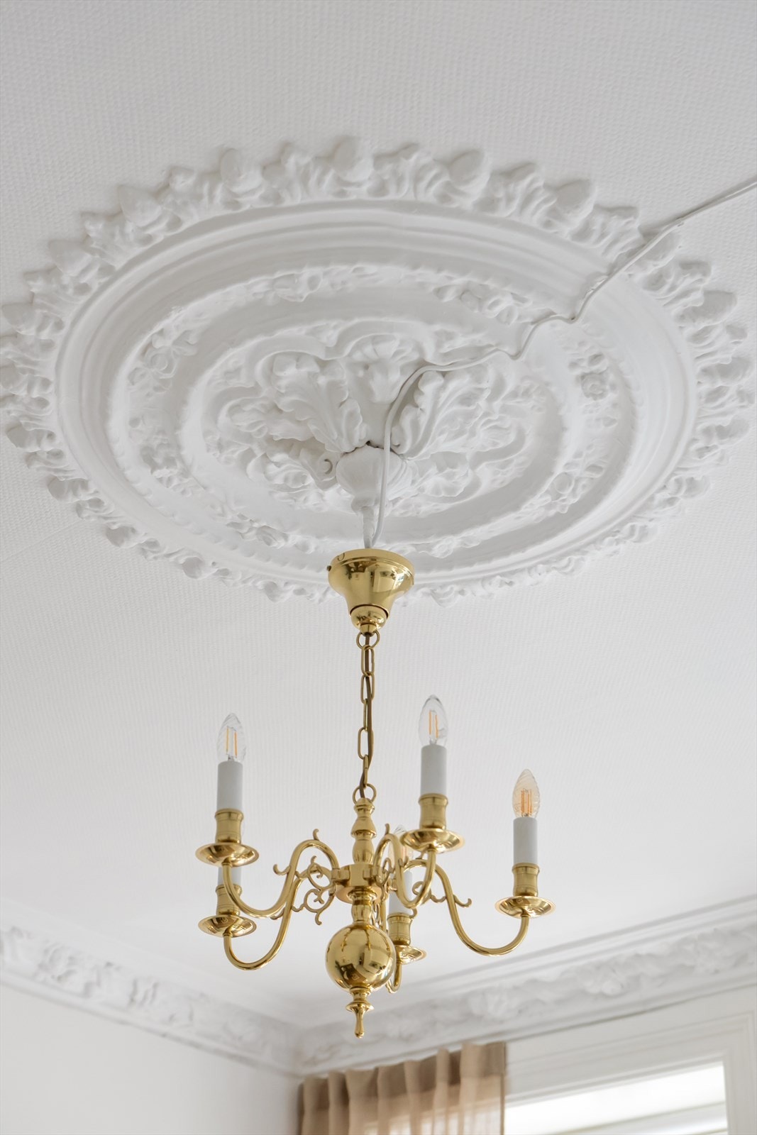 Stuen er utstyrt med en dekorativ rosett i taket, som tilfører eleganse og karakter til rommet. Galleribilde