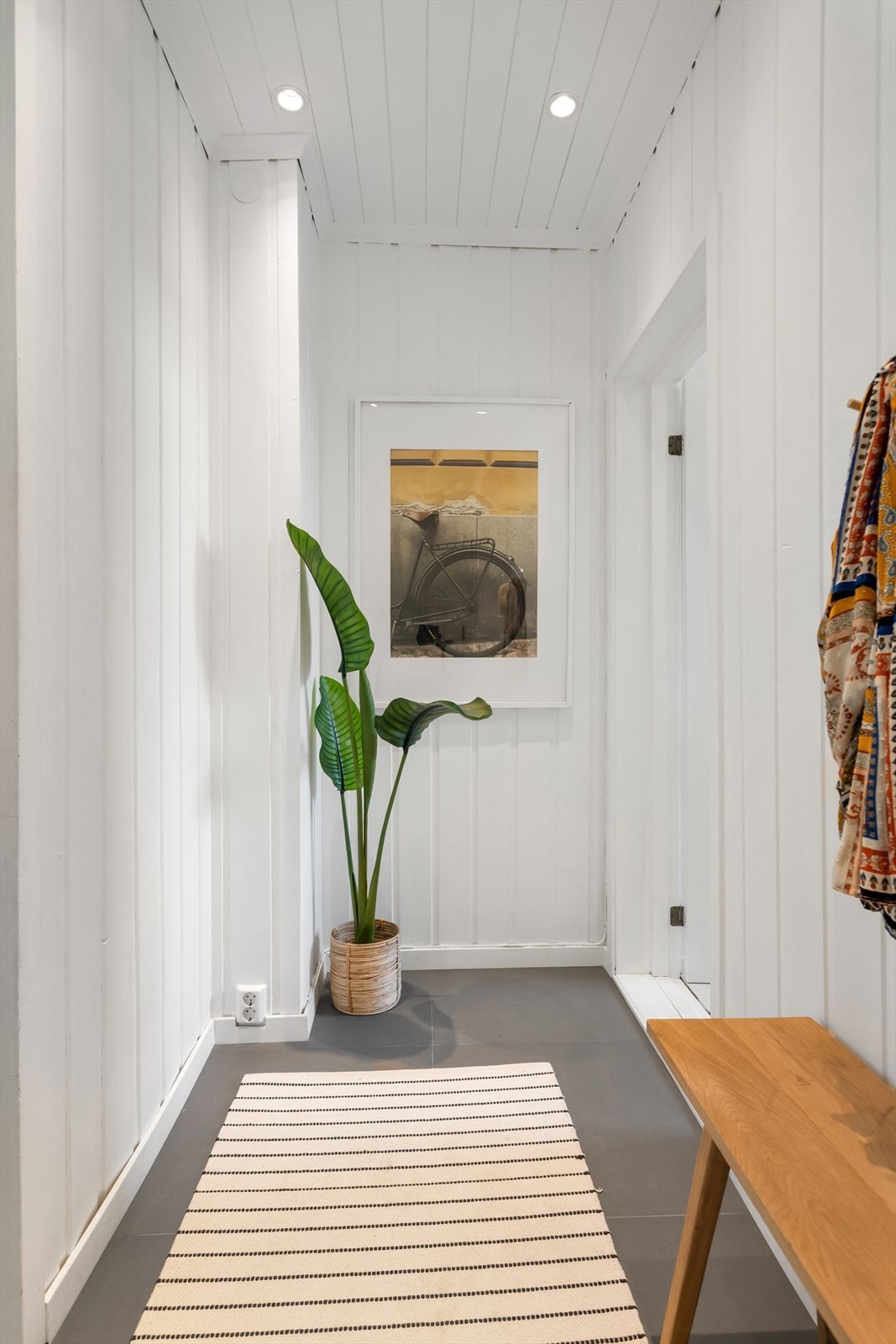 I entréen er det lagt praktiske fliser, mens resten av boligen har gjennomgående malte gulvbord som gir et helhetlig og stilrent uttrykk. Galleribilde