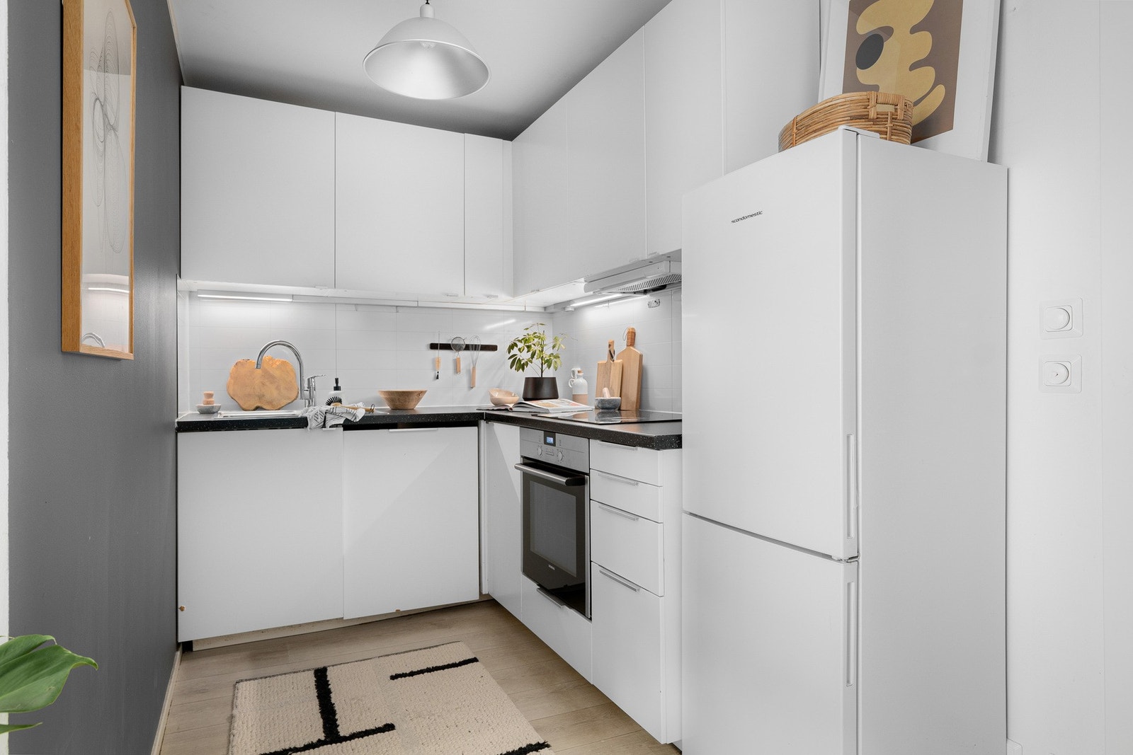 Hvit og tidløs kjøkkeninnredning med både overskap og skuffer for optimal oppbevaring Galleribilde