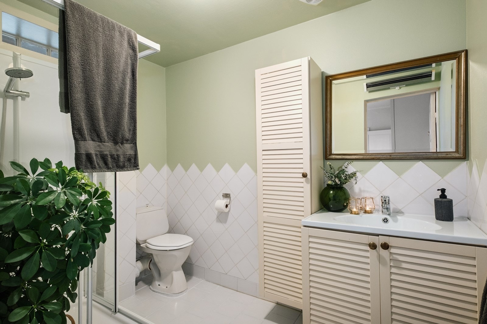 Eldre bad med keramiske fliser på vegg opp til ca. 1,21 meter. Derfra er det platede vegger belagt med strie og keramiske fliser på gulv. Galleribilde