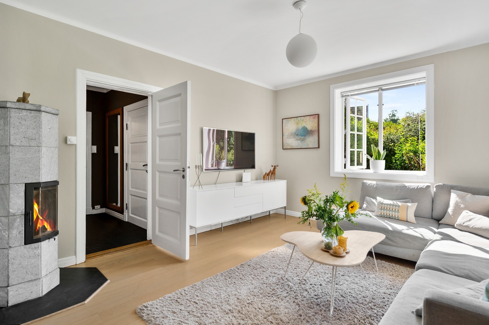 Stue med lekker klebersteinsovn - sjarmerende sprossevinduer med nydelig utsikt mot hagen på alle kanter Galleribilde