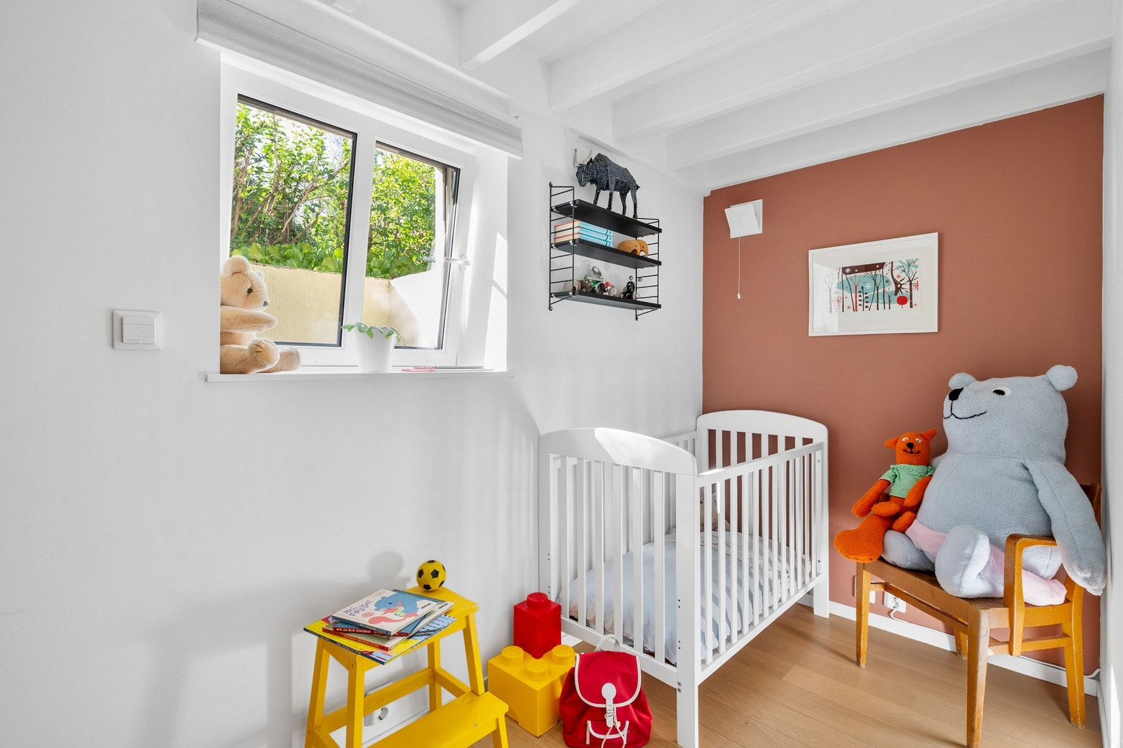 Lunt rom med karakterfulle, synlige takbjelker og utsyn mot hagen. Galleribilde