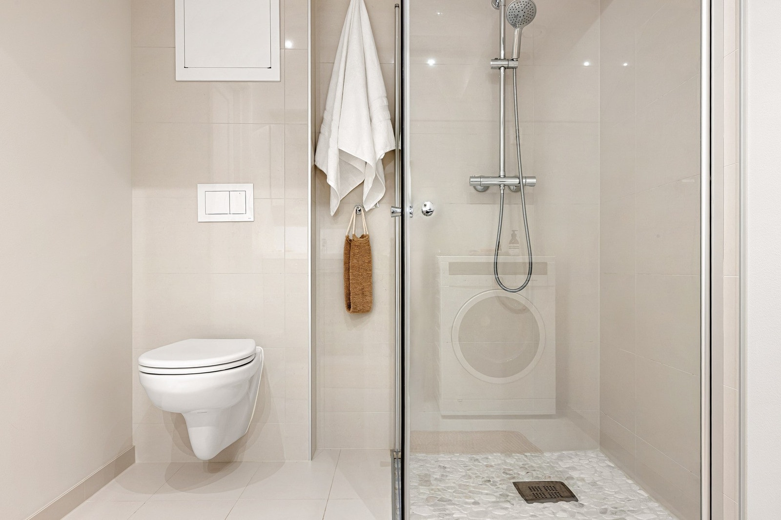 På badet er det baderomsinnredning med nedfelt servant, vegghengt toalett, dusjhjørne og opplegg for vaskemaskin. Galleribilde