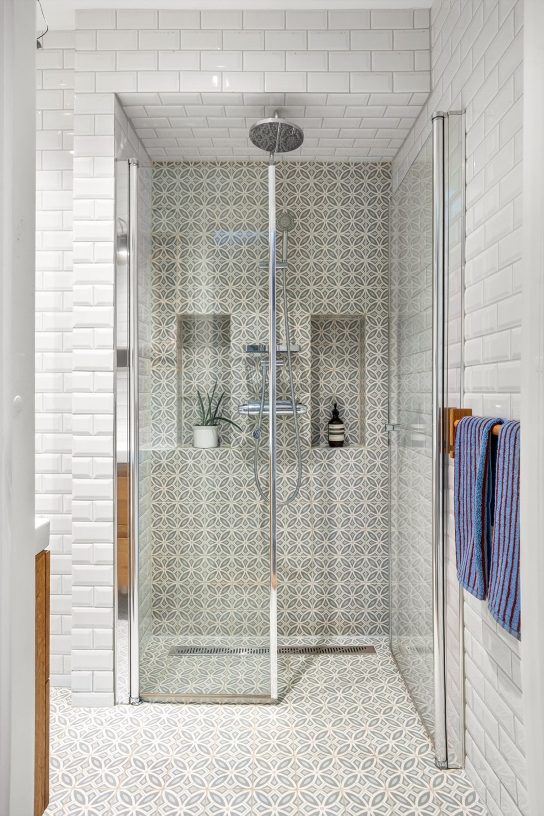 Badet er utstyrt med servant med underskap, speil, veggmontert toalett og dusjhjørne med to svingbare glassdører. Galleribilde