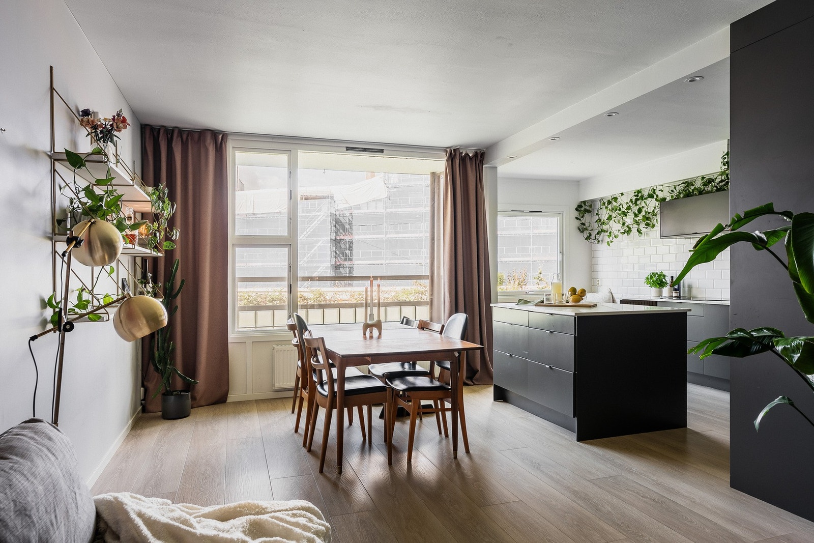 Store, nordvestvendte vinduer sikrer unik, naturlig lyssetting til allrommet som utgjør stue og kjøkken. Galleribilde