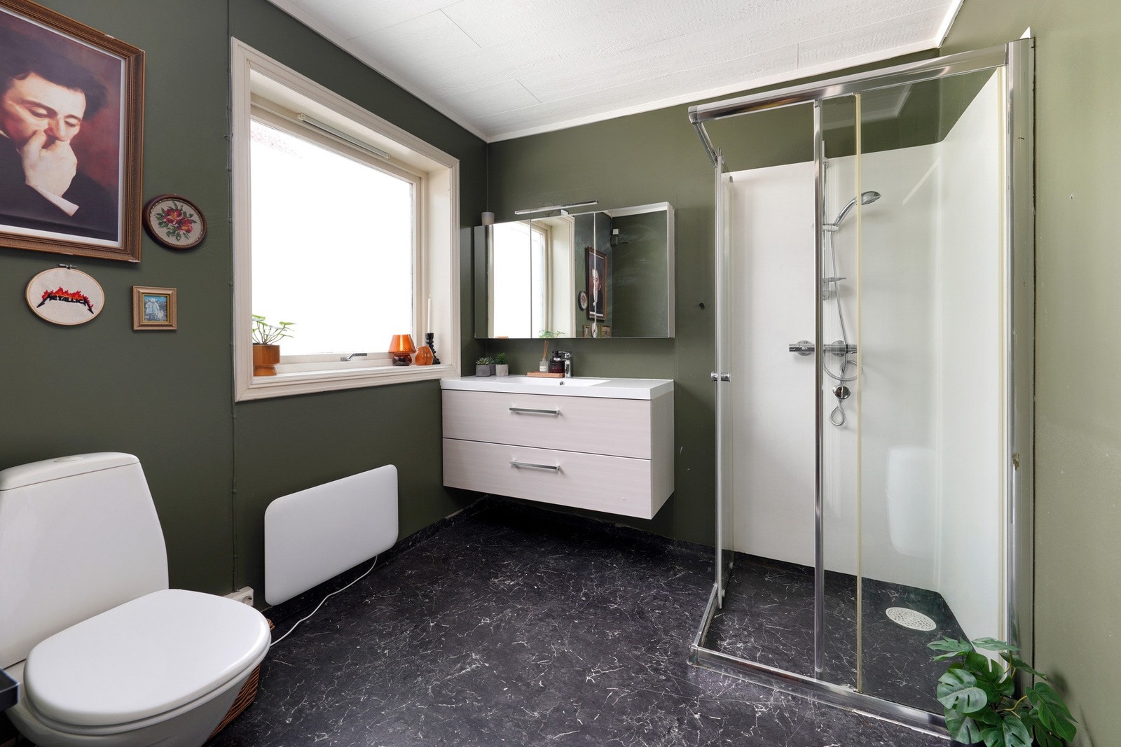 Romslig bad med panelovn og stort vindu som slipper inn rikelig med naturlig lys Galleribilde