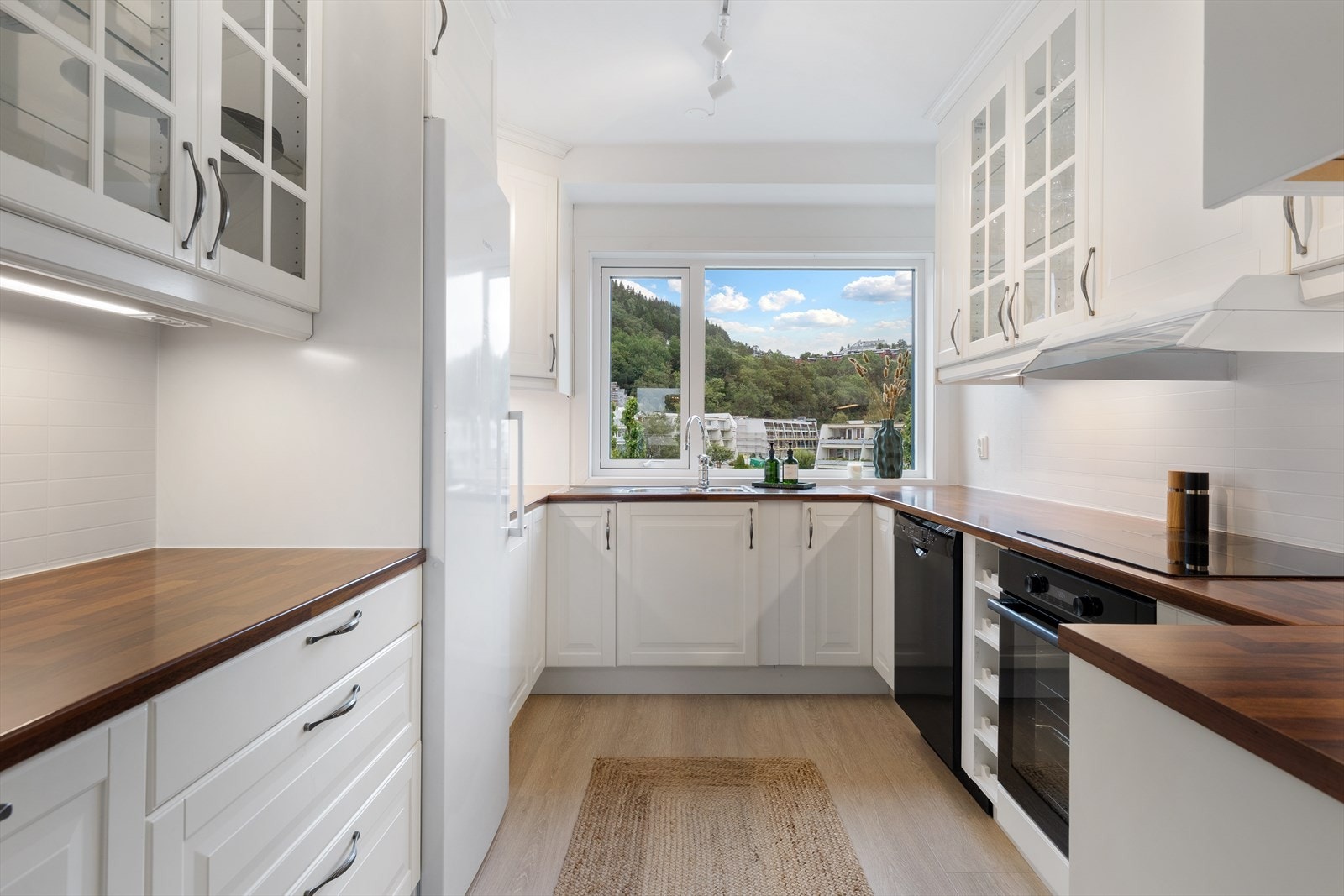 Innredningen består av klassiske, profilerte fronter i hvitt med overskap som strekker seg helt til tak - noe som gir både et helhetlig uttrykk og ekstra oppbevaringsplass Galleribilde